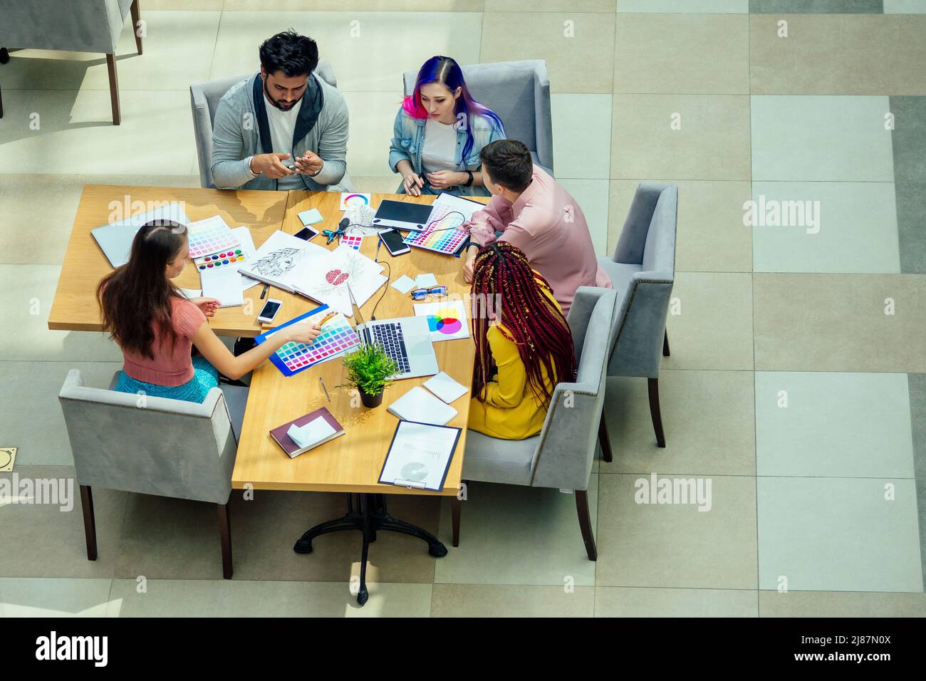 mixed-race journalist fashion designers working together in a bright office Stock Photo