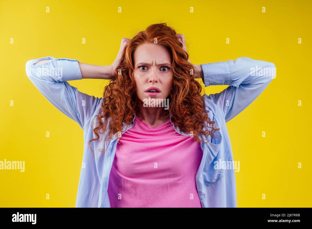 hair loss treatment prevention concept. luxury volume curly redhead ginger young woman proud her lion's mane studio yellow background Stock Photo