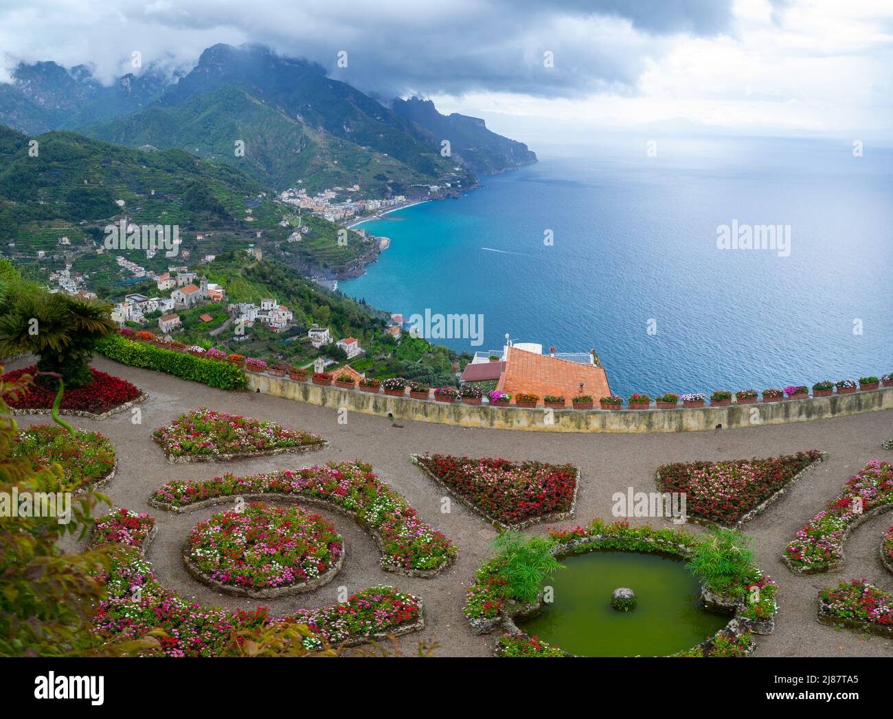 Colorful flower beds of Villa Rufolo garden with Amalfi Coast in background, Ravello Stock Photo