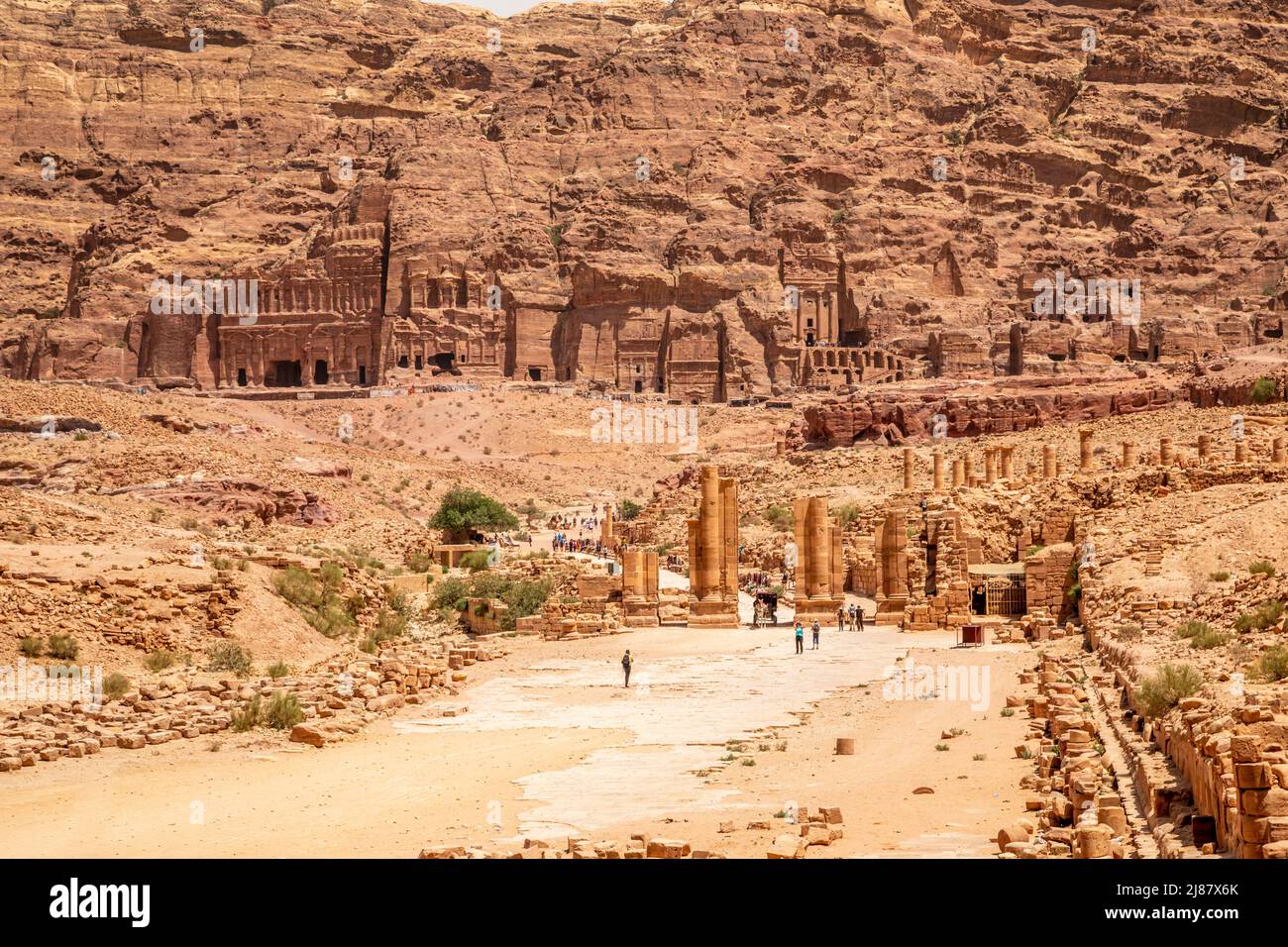 Petra main street with ancient Nabataean Royal tombs in the background and ruins of grand temple in the foreground, Petra, Jordan Stock Photo