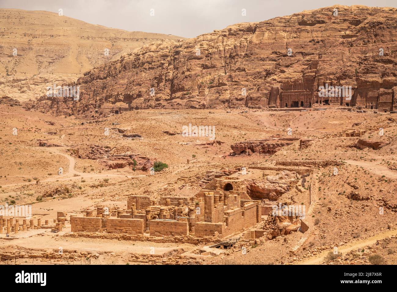 Ancient Nabataean Royal tombs in the background and ruins of grand temple in the foreground, Petra, Jordan Stock Photo