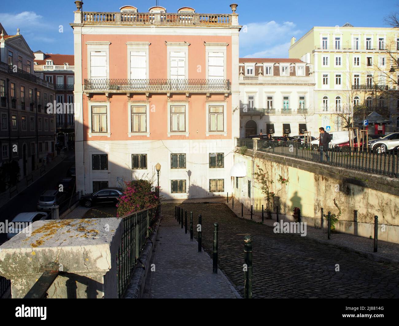 Cobblestone sloping ramp from Praca do Principe Real to R. Cecilio de Sousa, view in afternoon shadows, Lisbon, Portugal Stock Photo