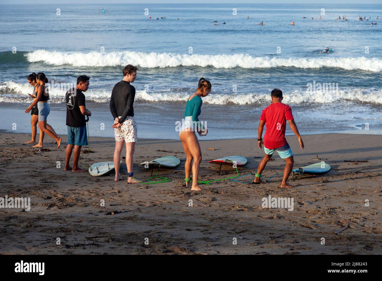 Surf instructors with their students teaching surf moves before going