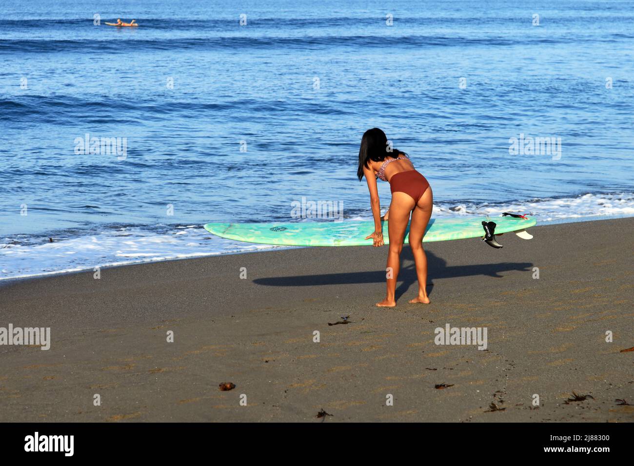 A young Indonesian Asian woman with long black hair wearing a brown ...