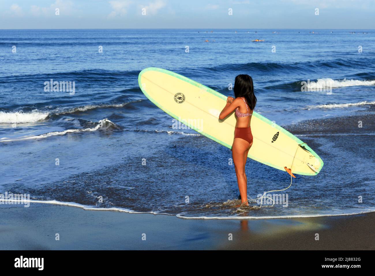 A young Indonesian Asian woman with long black hair wearing a brown