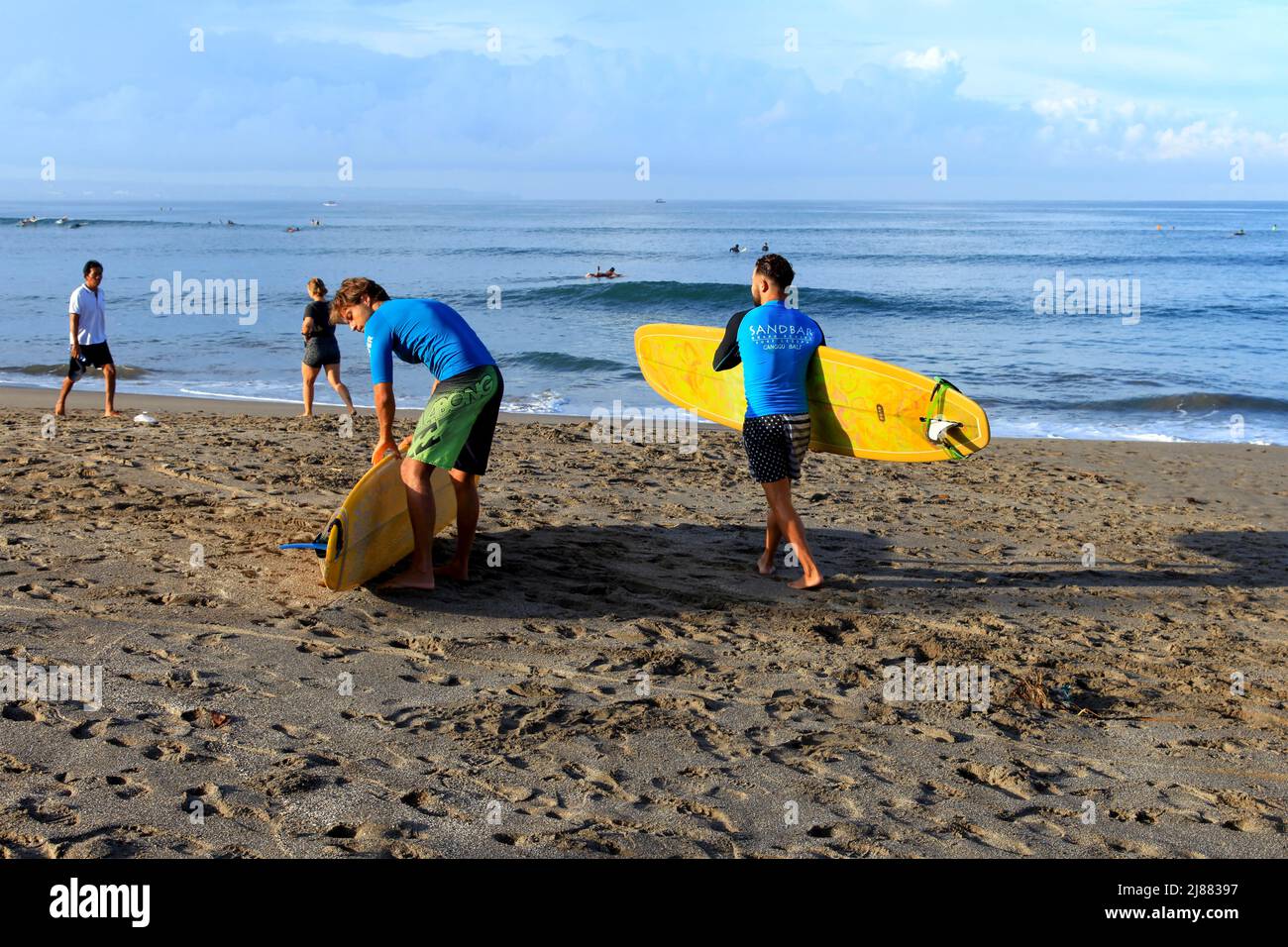 Two male caucasian surfers standing at Batu Bolong Beach in Canggu, Bali, Indonesia carrying their long boards or malibu surfboards. Stock Photo