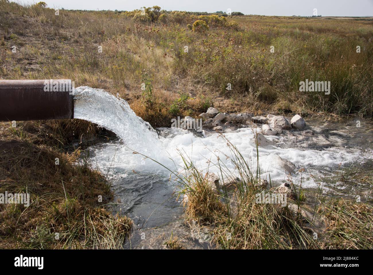 Irrigation water pours from a large pump and pipe on Camas National Wildlife Refuge, Hamer, Clark County, Idaho, USA Stock Photo