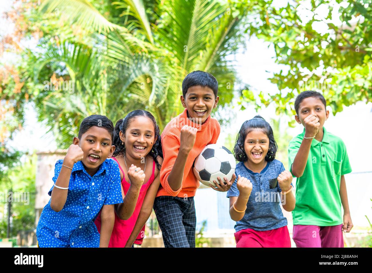 group of teenager kids with football shouting by looking at camera - conecept of excitement, entertainment and competition Stock Photo