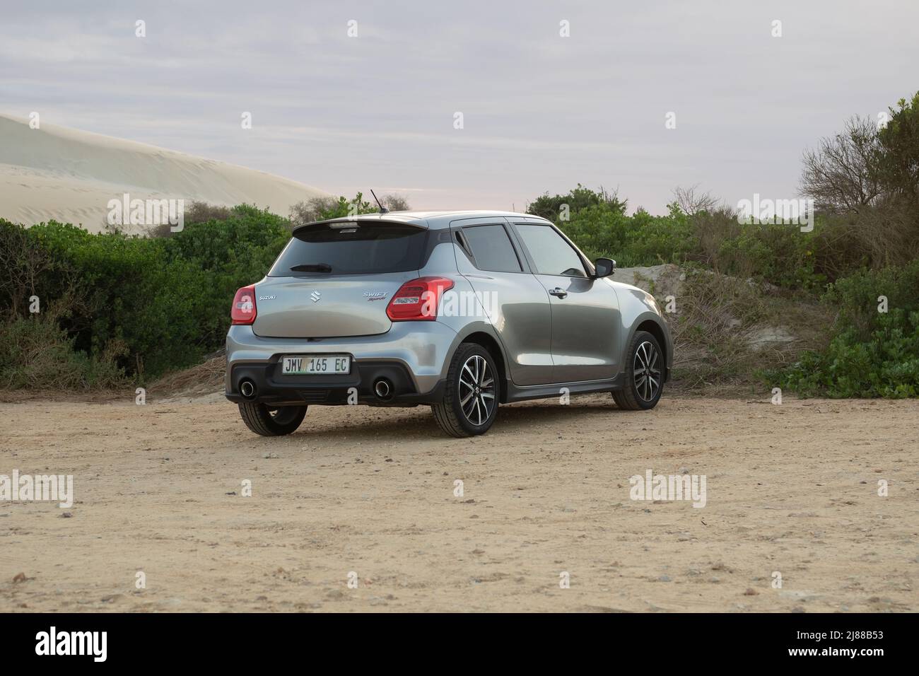 Cape Town, South Africa. 14 May 2022. A silver Suzuki Swift Sport parked on the gravel parking of a beach. Stock Photo