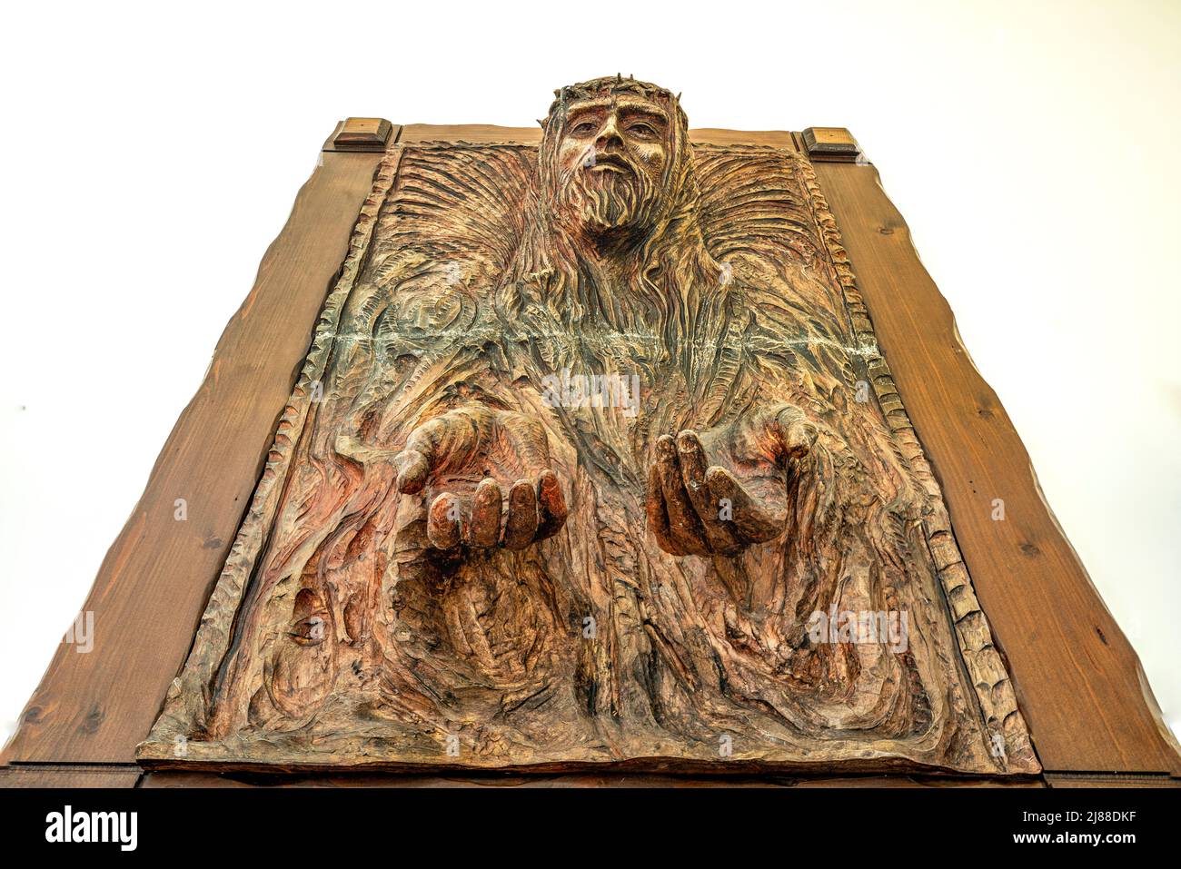 Artist's impression of Jesus with the crown of thorns. Wooden sculpture with face and hands coming out of the wooden plane. Ischitella, Puglia Stock Photo