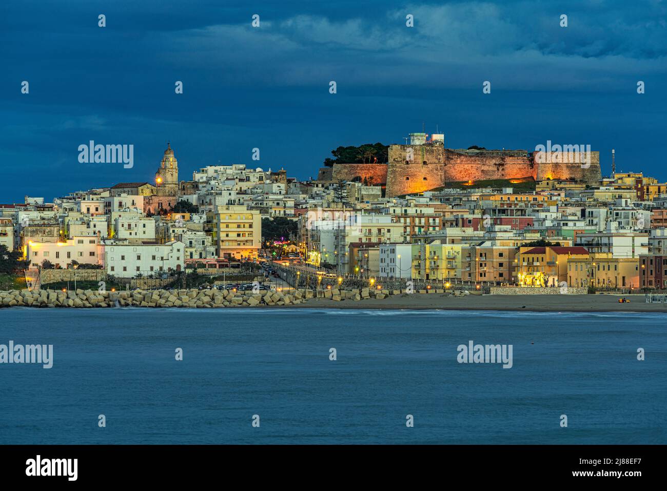 View of Vieste with artificial lights at dusk. Vieste. province of Foggia, Puglia, Italy, Europe Stock Photo