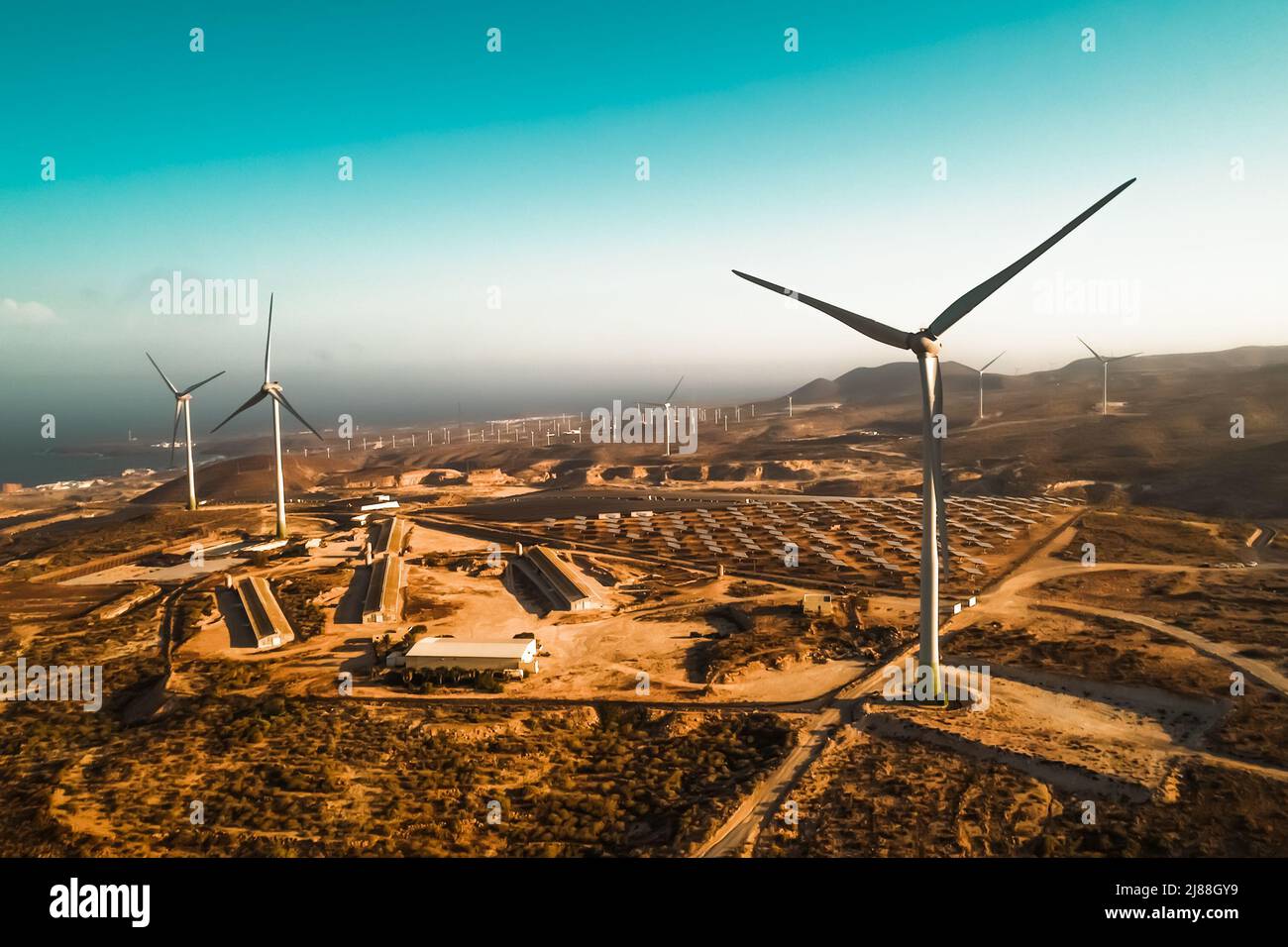 Panoramic view of wind turbine and solar panels in background - Sustainable environment concept Stock Photo