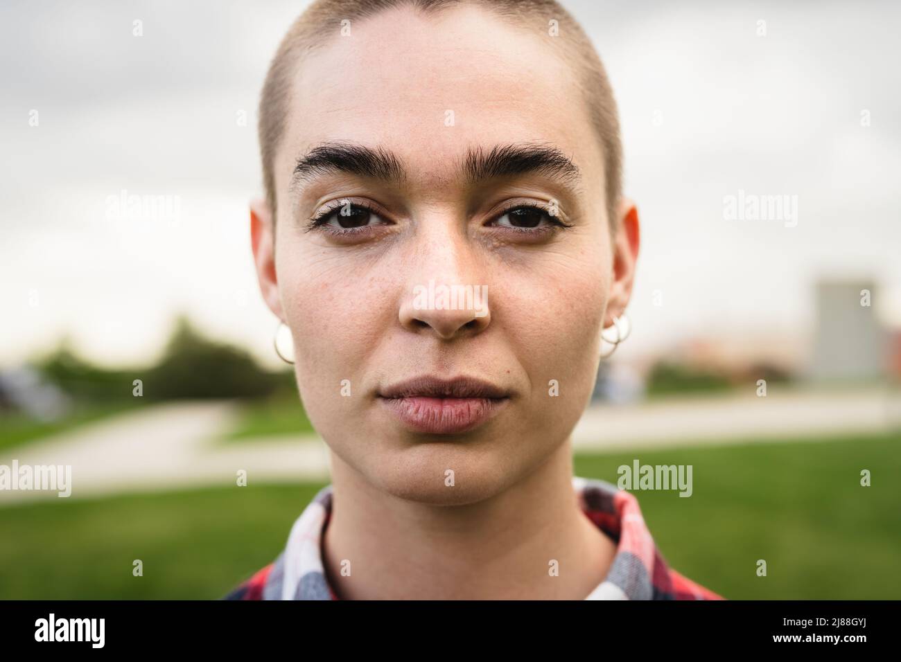 Shaved head girl looking at camera portrait Stock Photo