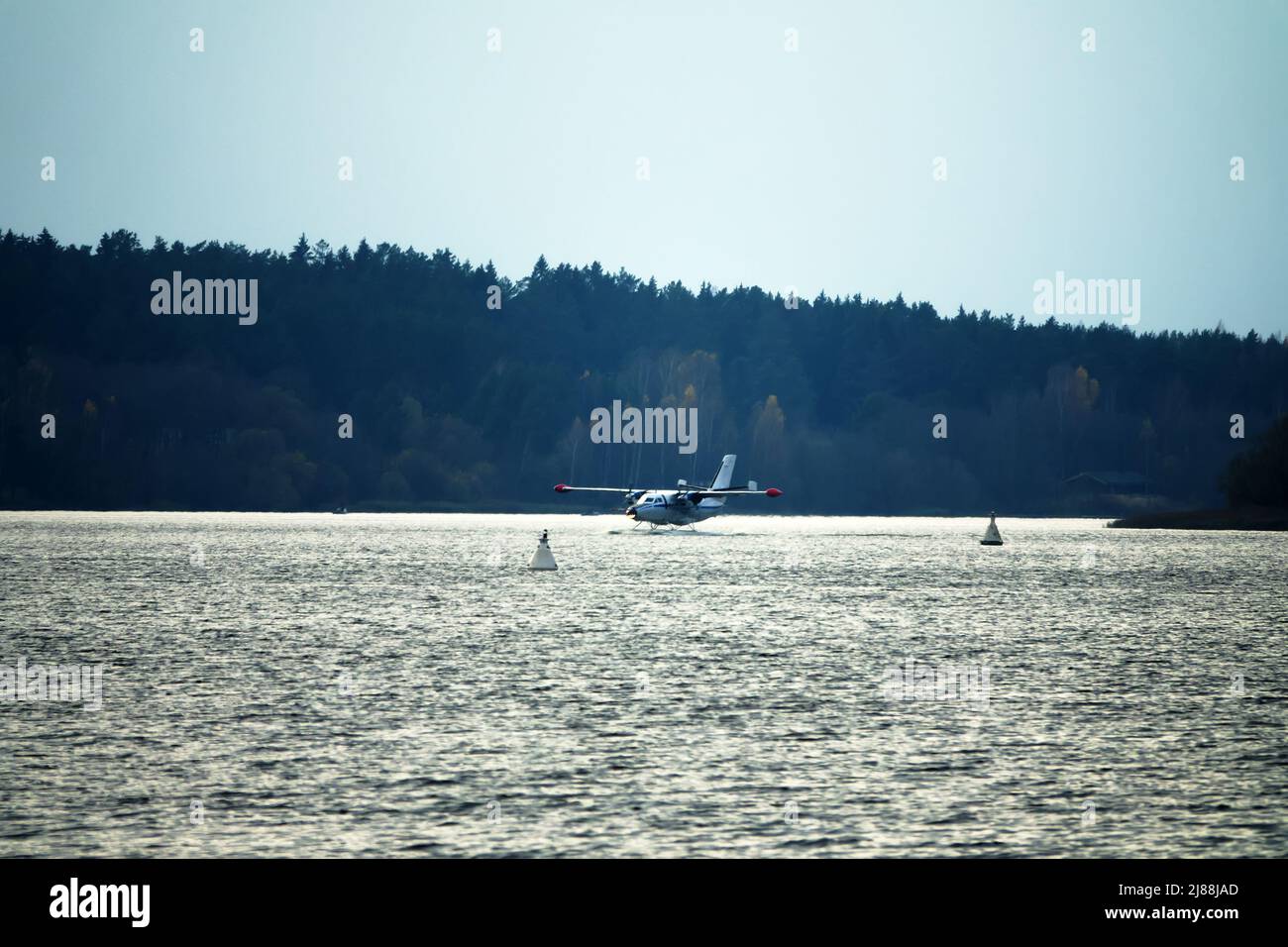 The Twinengine seaplane a seaplane rises from water, from the forest