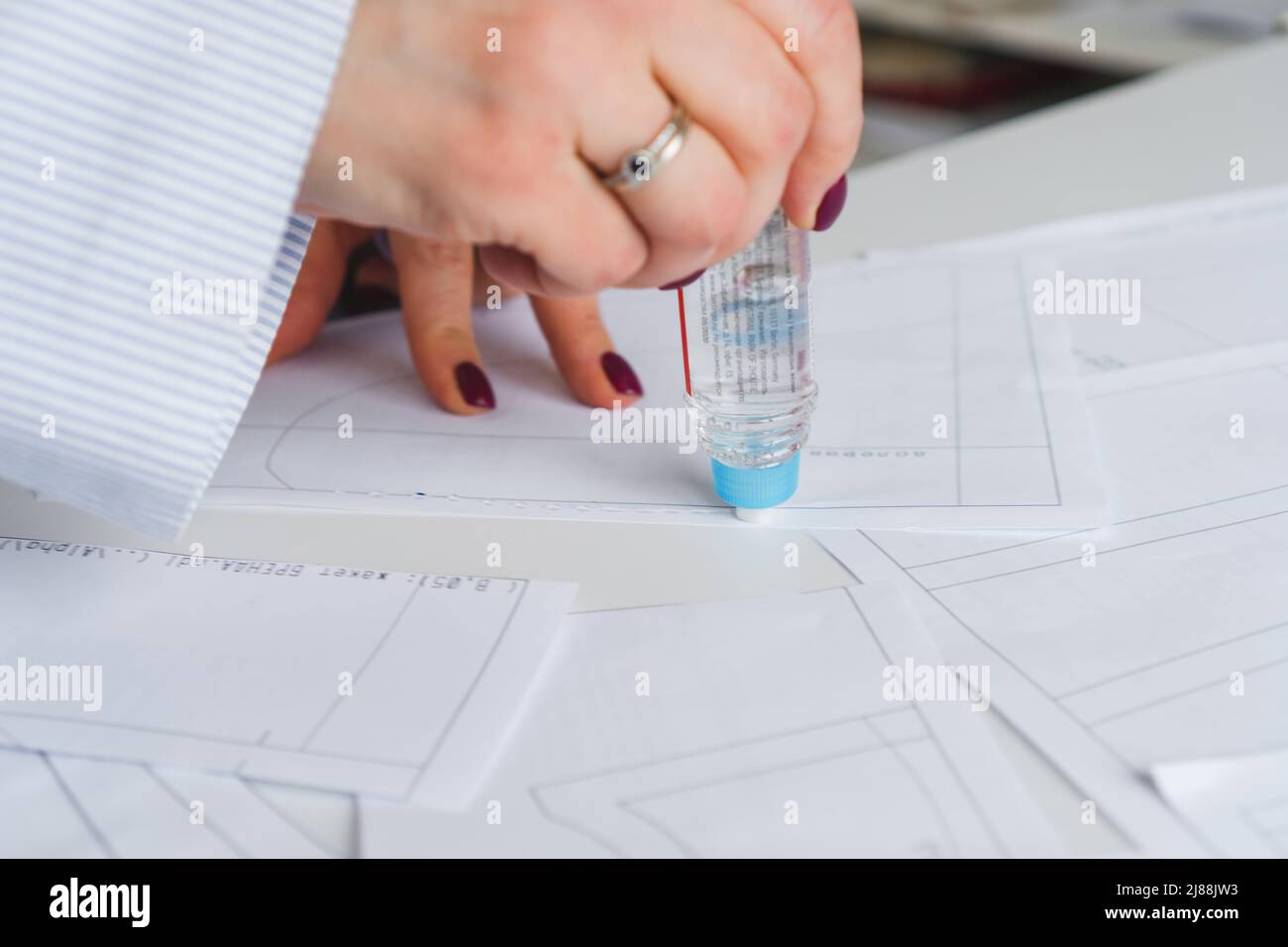 Woman tailor during work on sewing patterns. Seamstress glue together