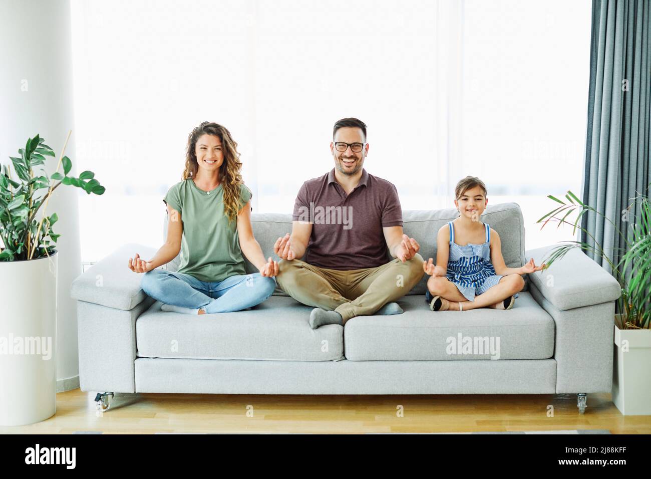 child yoga famil mother home woman exercise girl father fitness together daughter Stock Photo