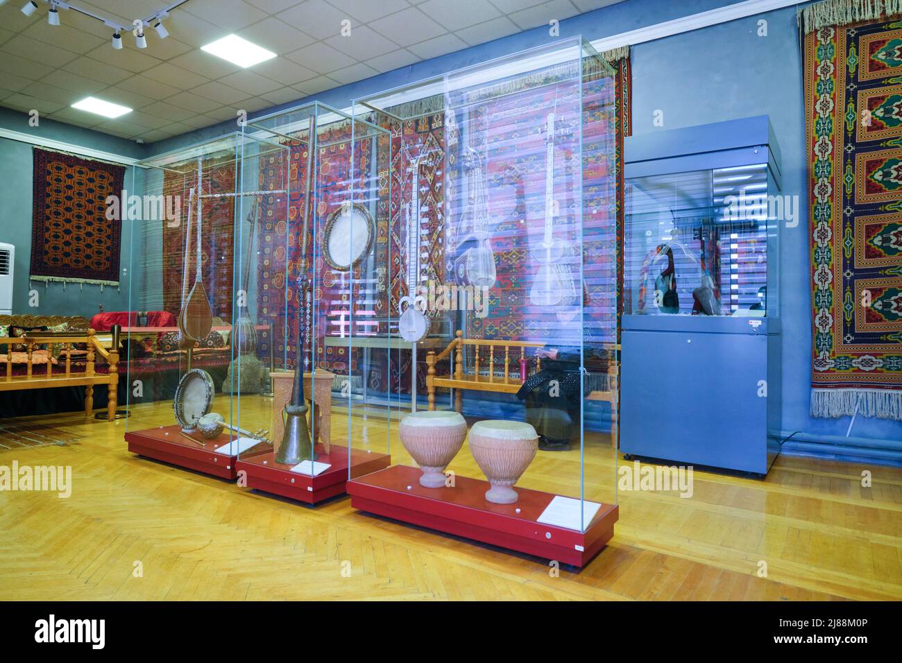 A room displaying musical instruments and hanging rugs. At the Museum of Applied Arts in Tashkent, Uzbekistan. Stock Photo