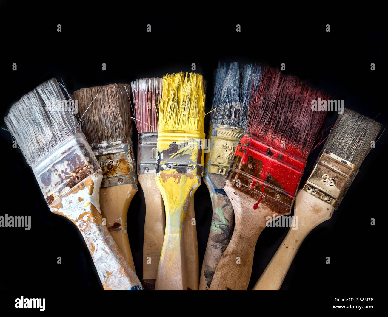Bunch of used and dried paint brushes shot on black background Stock Photo