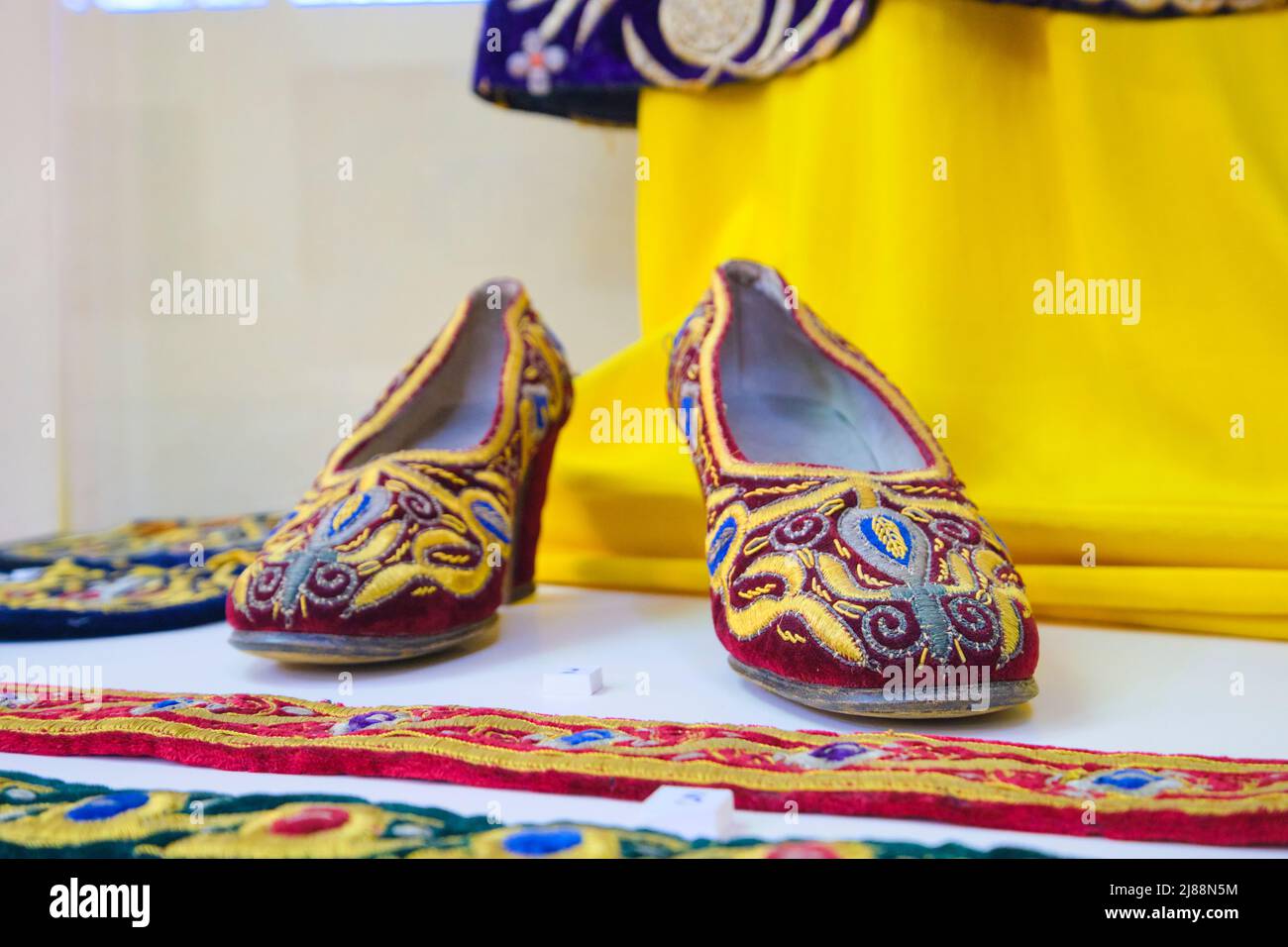 Women's shoes covered with traditional colorful, rich embroidery. At the Museum of Applied Arts in Tashkent, Uzbekistan. Stock Photo