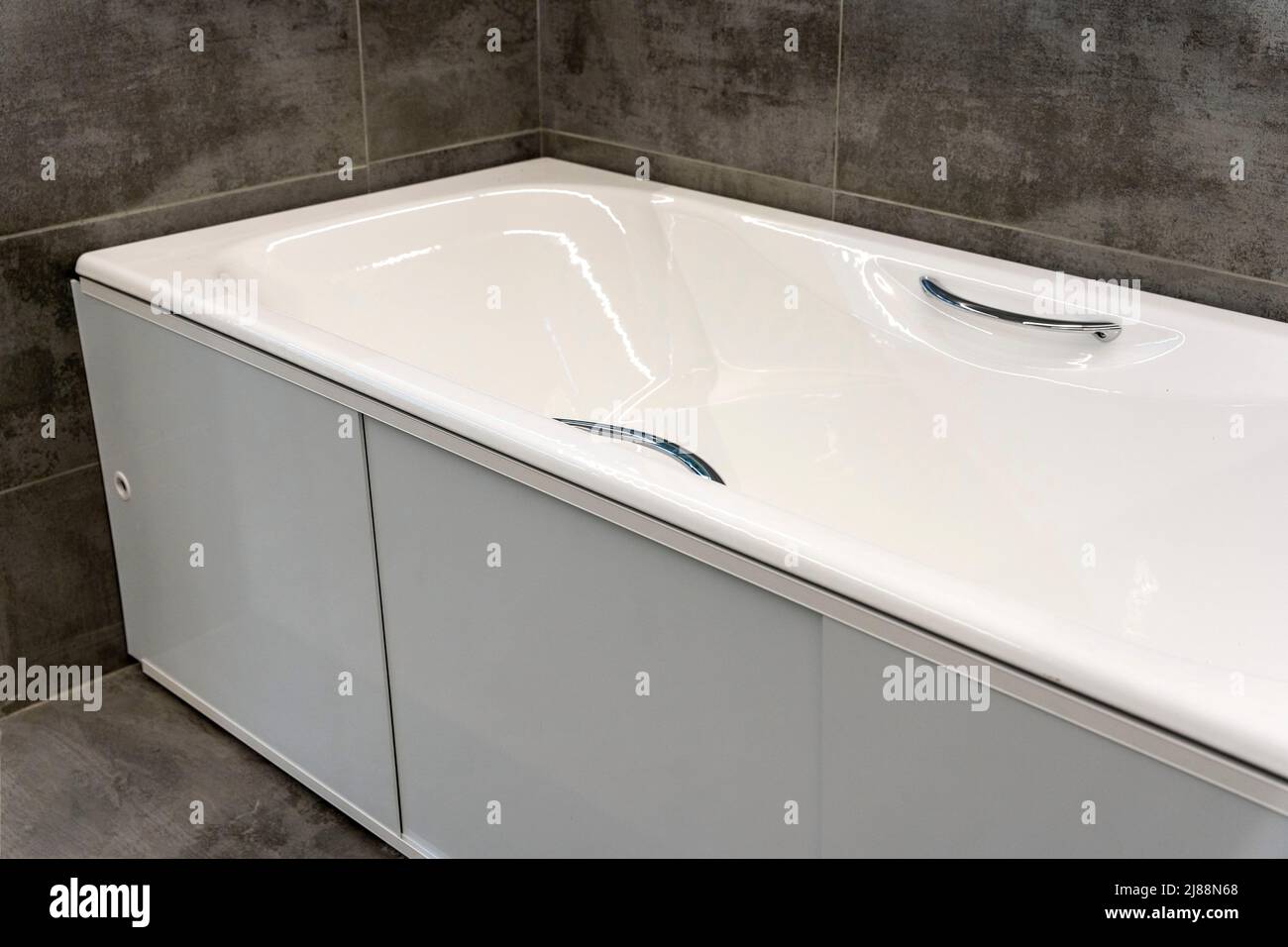 New Bathtub installed in the bathroom with ceramic finish Stock Photo