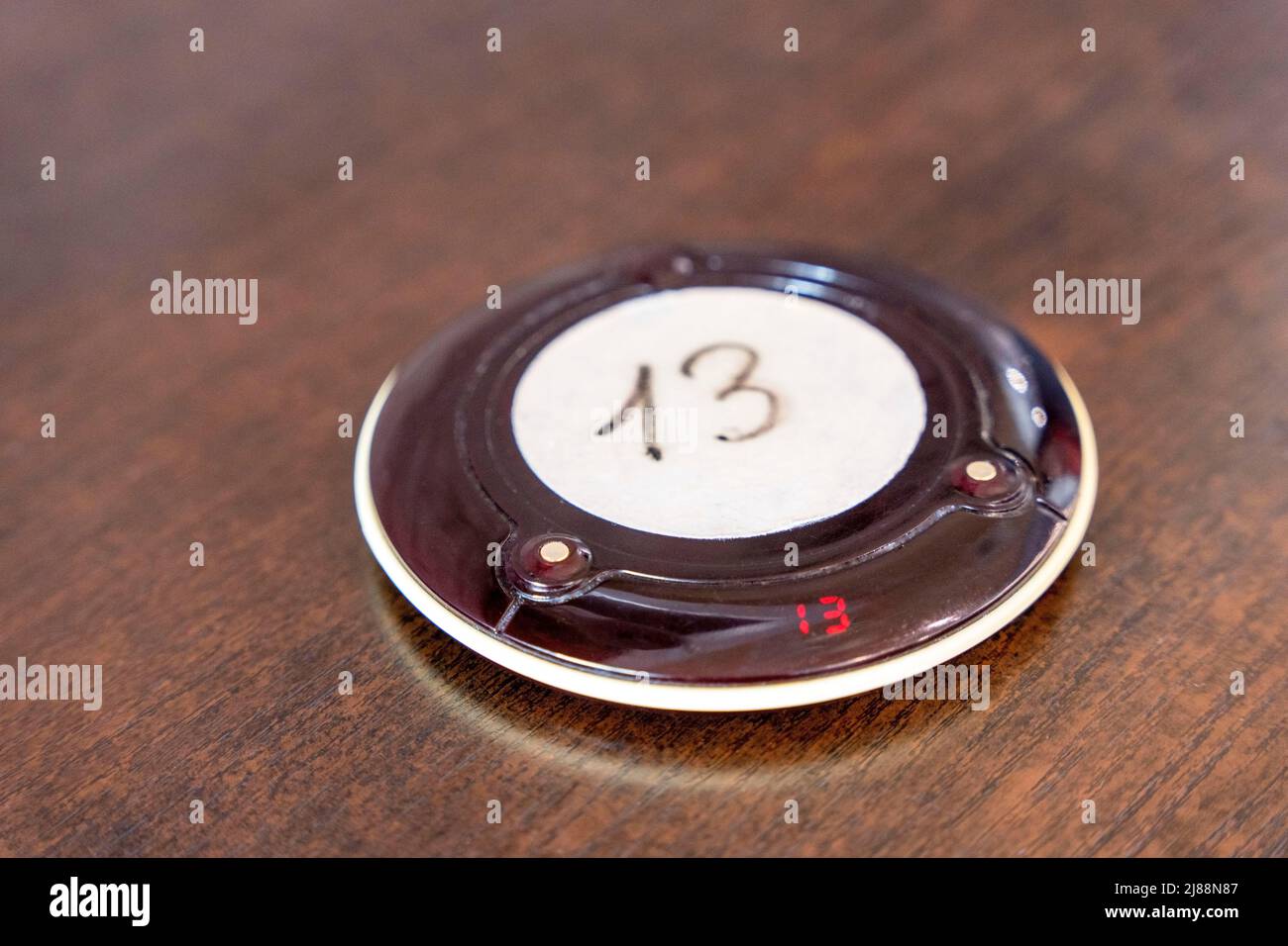 Wireless queue calling system. a pager for a restaurant with number 13 Stock Photo