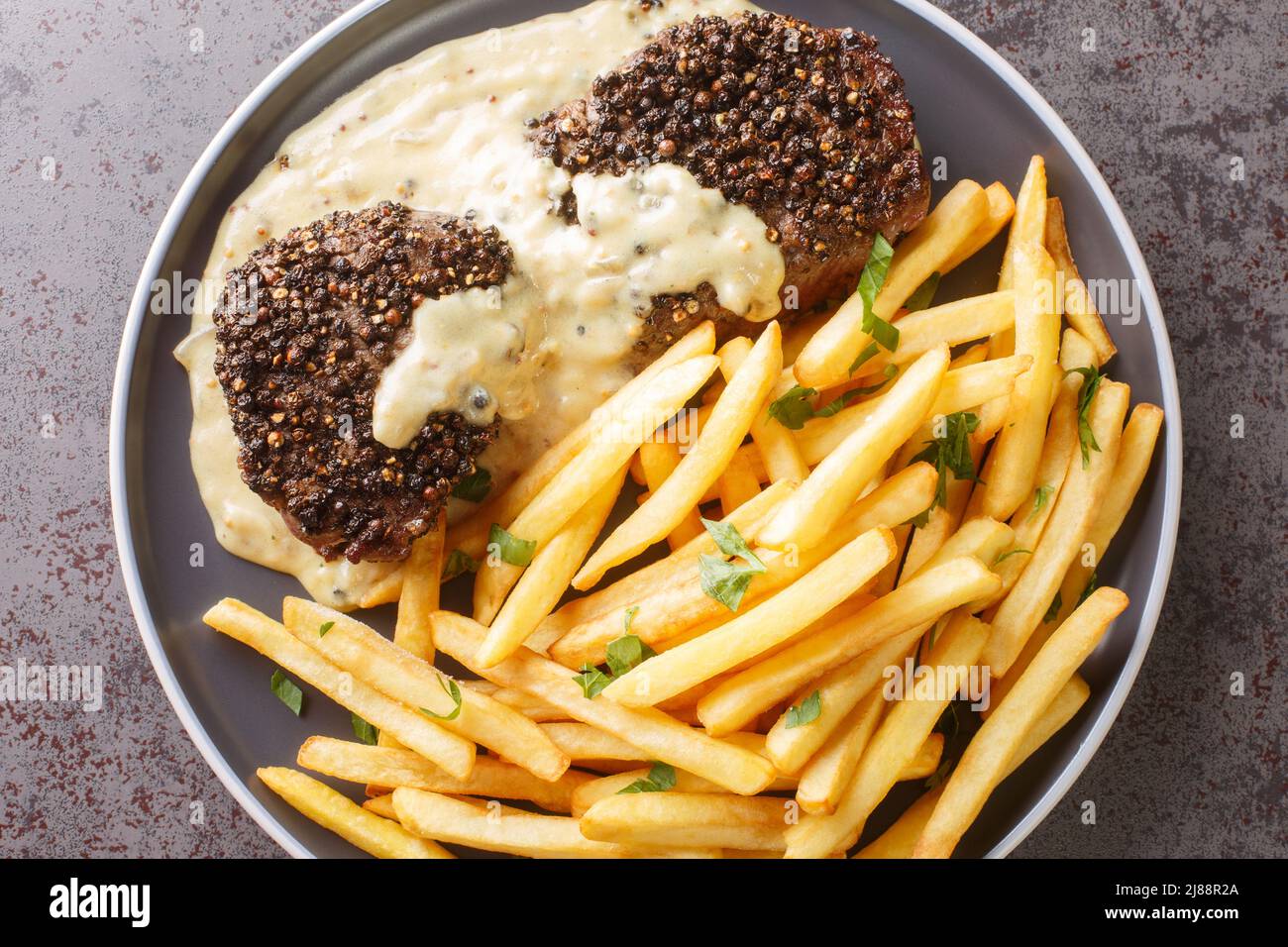 Steak au Poivre with Cognac Cream Sauce and french fries closeup in a