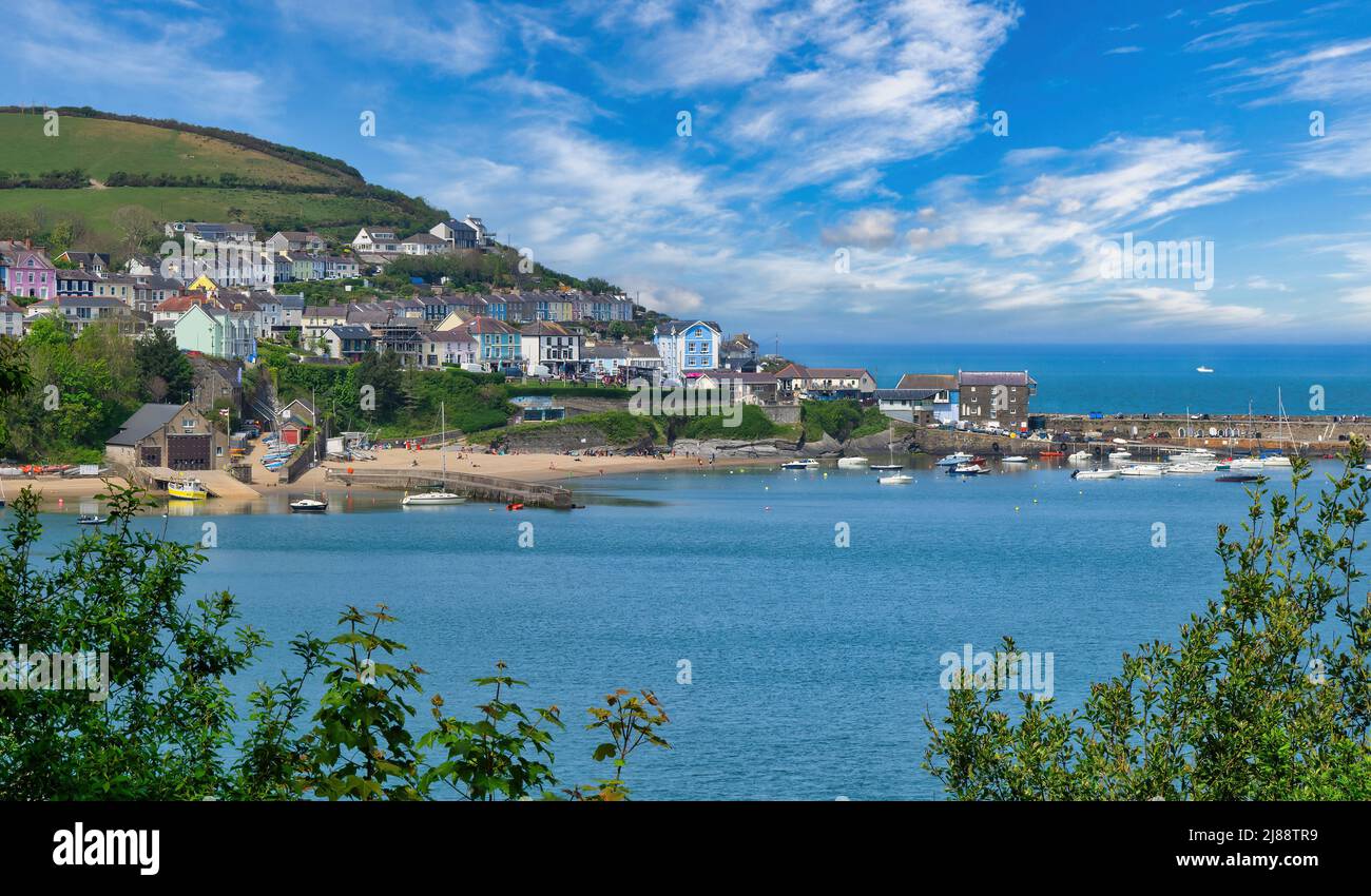 A glimpse through the trees of one of Wales' most picturesque harbour towns and once home to Dylan Thomas. Taken from the Welsh Coast Path Stock Photo