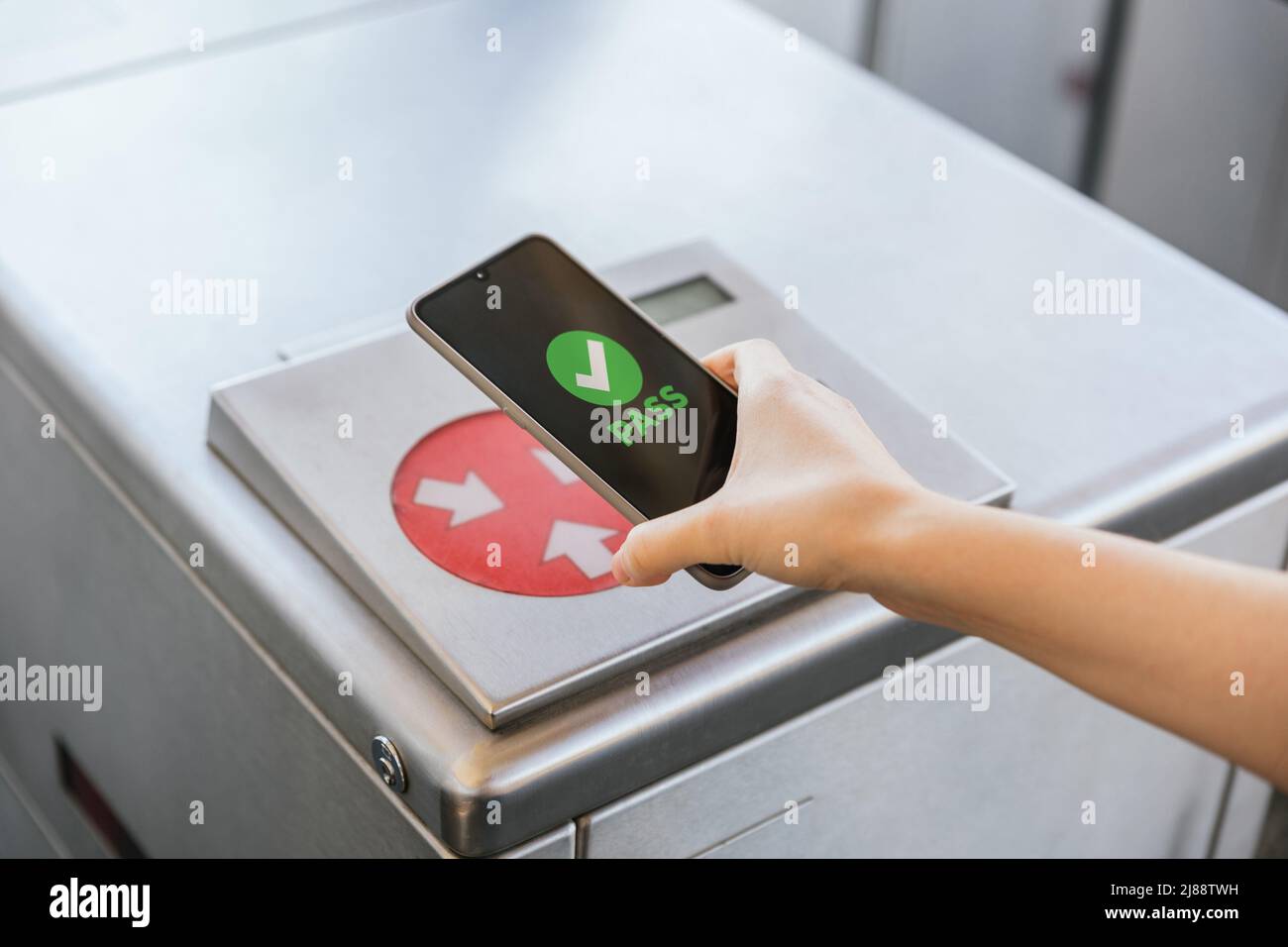 Close up of a woman pays her transport ticket in the machine with her mobile phone on train station. NFC and contactless technology concept Stock Photo