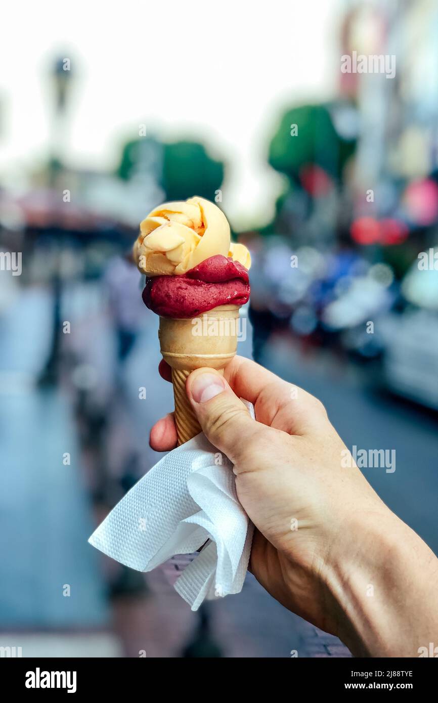 Turkish ice cream Dondurma in hand on the background of the city Stock Photo