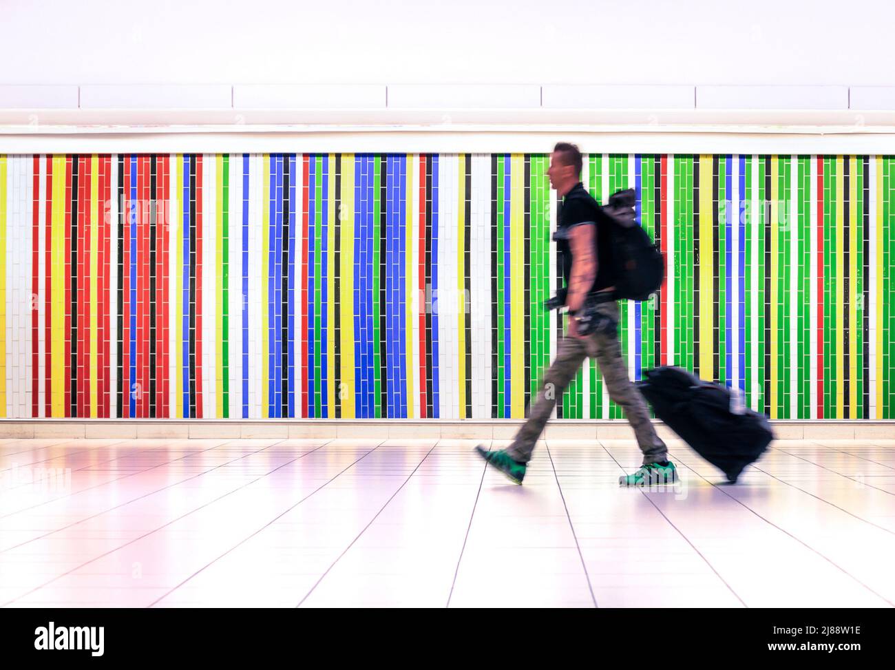 Motion blur of man walking at international airport with suitcase and backpack - Concept of alternative lifestyle traveling around the world Stock Photo