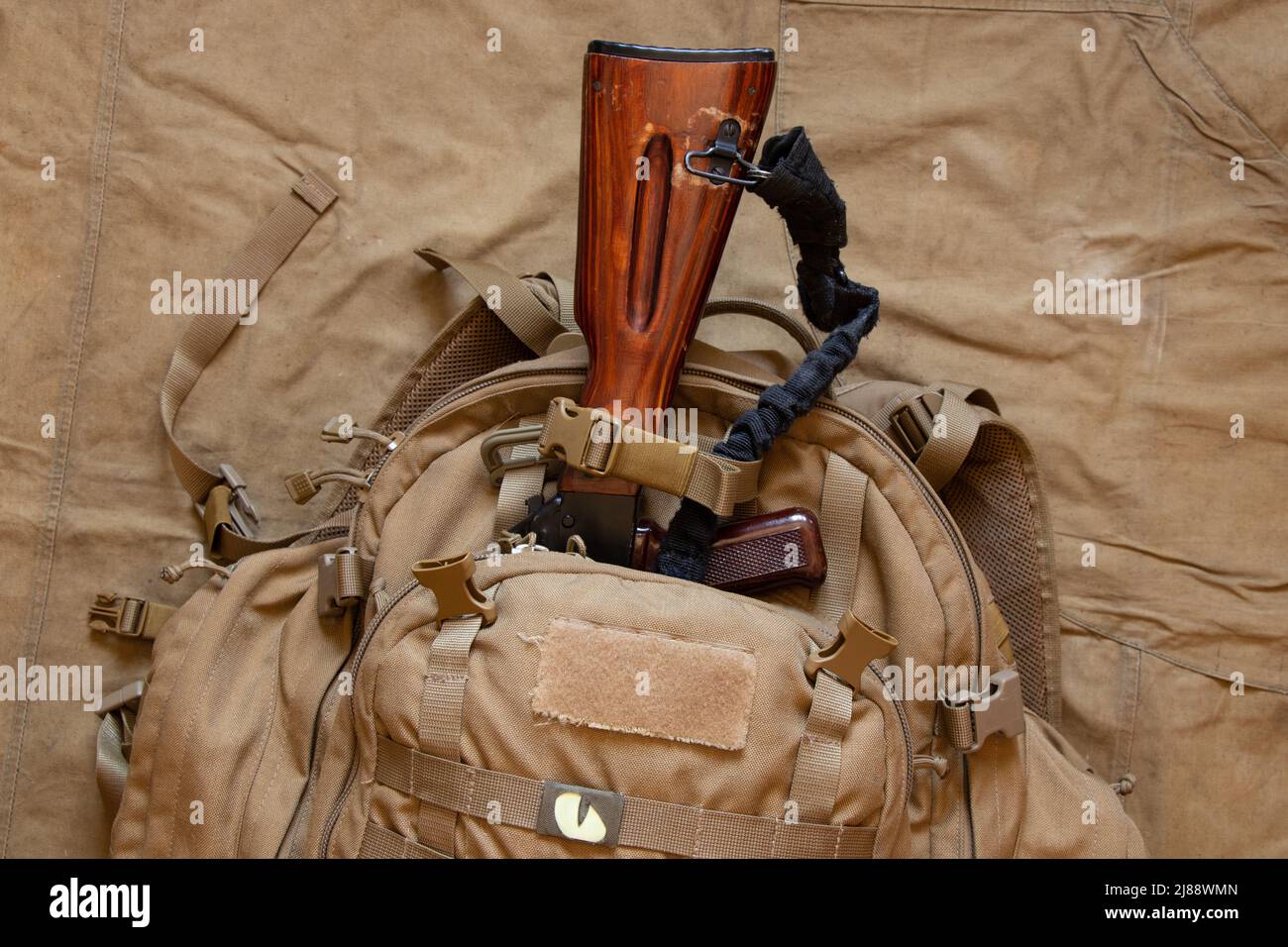 Military green backpack with a machine gun on a green background, backpack of a Ukrainian soldier, war in Ukraine Stock Photo