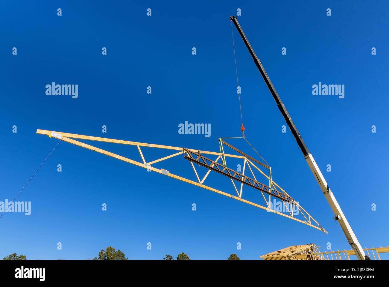 Crane holds the wooden roof with crane holds a roof truss beams for