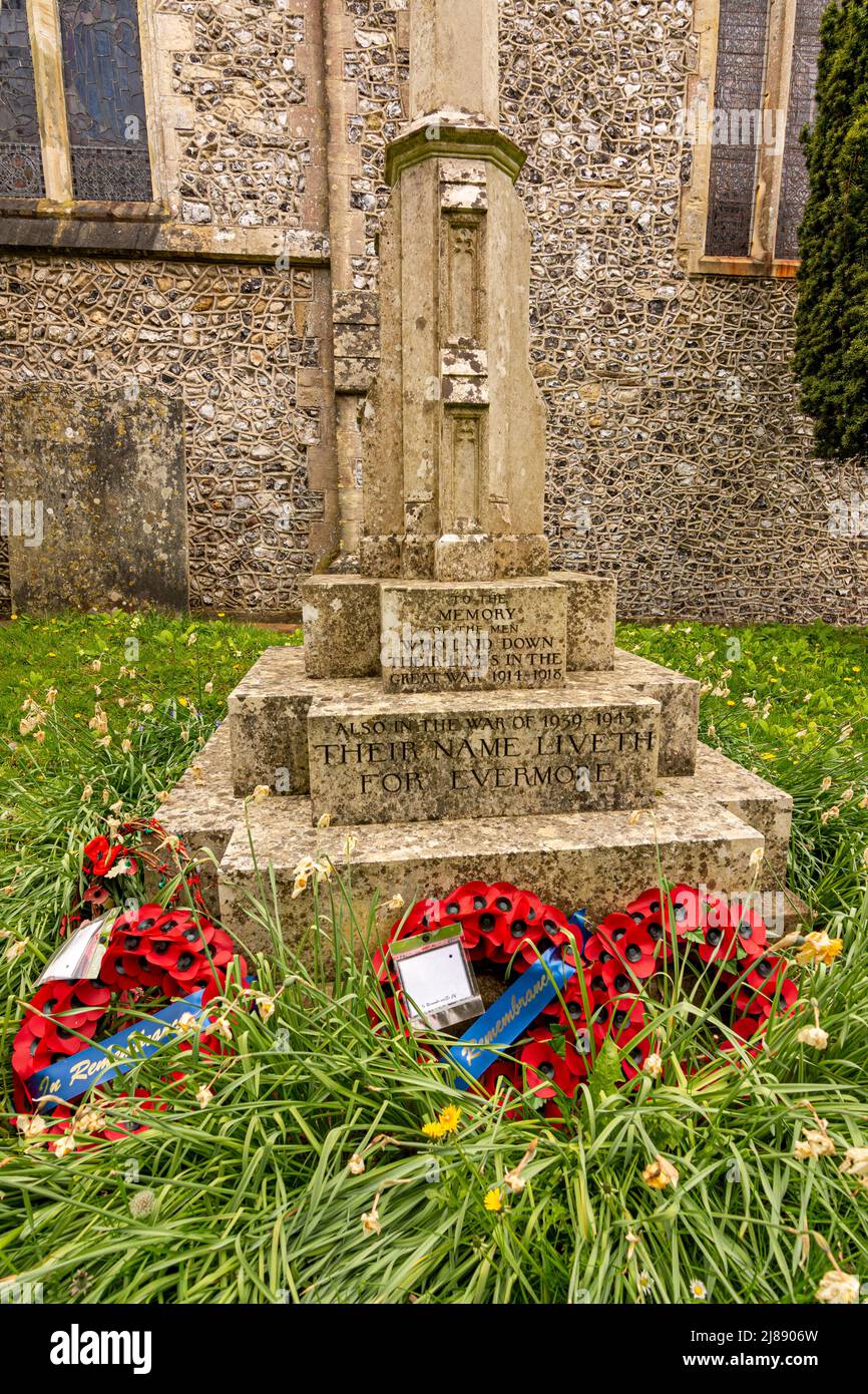 Wreaths from Remembrance Sunday in November, still lay at the foot of a War Memorial after Spring Daffodils have flowered and wilted. Stock Photo