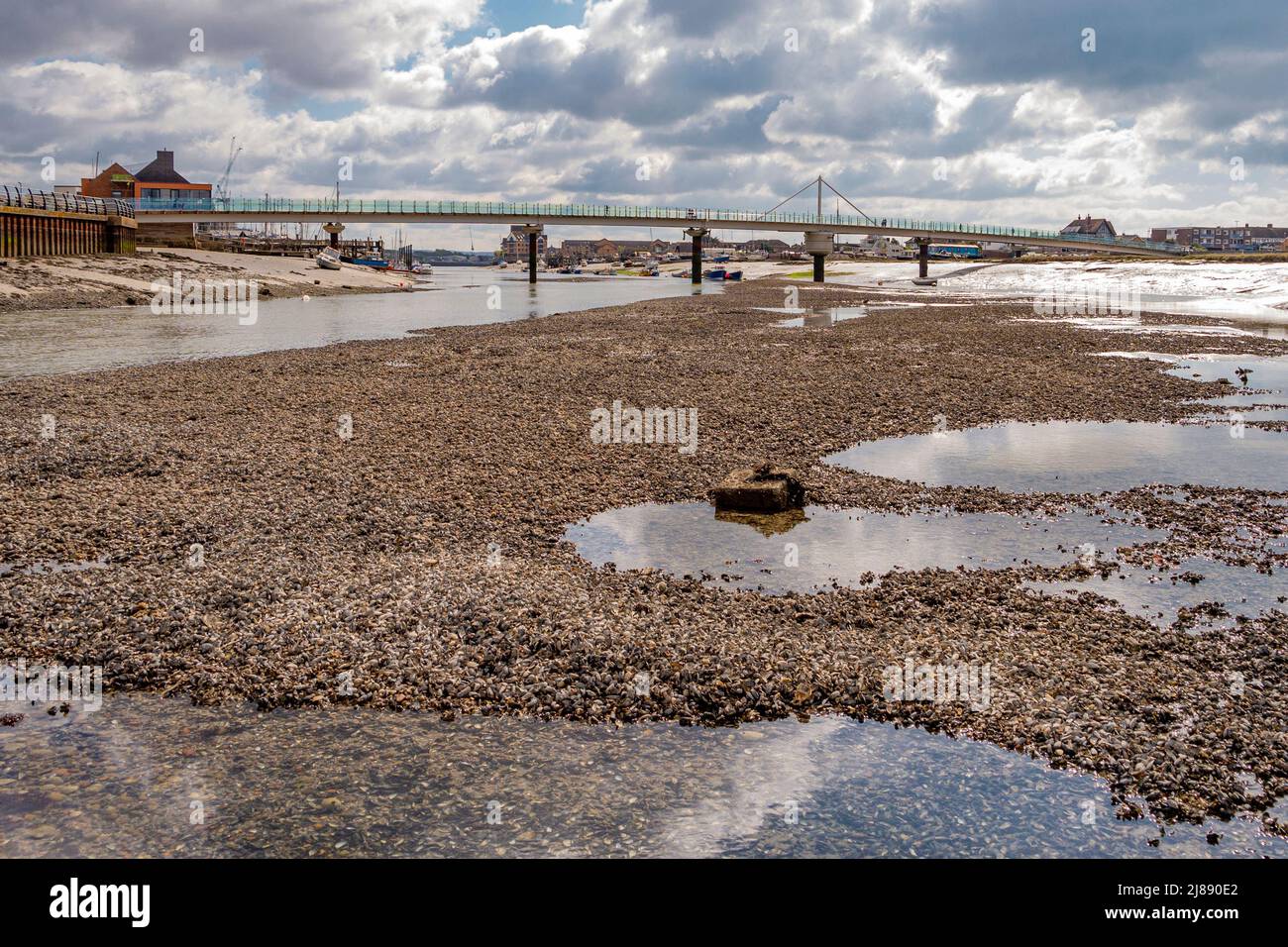 The River Adur at low tide, looking towards the footbridge & revealing an extensive river bed and an old mooring anchorage - Shoreham-By-Sea, Sussex. Stock Photo