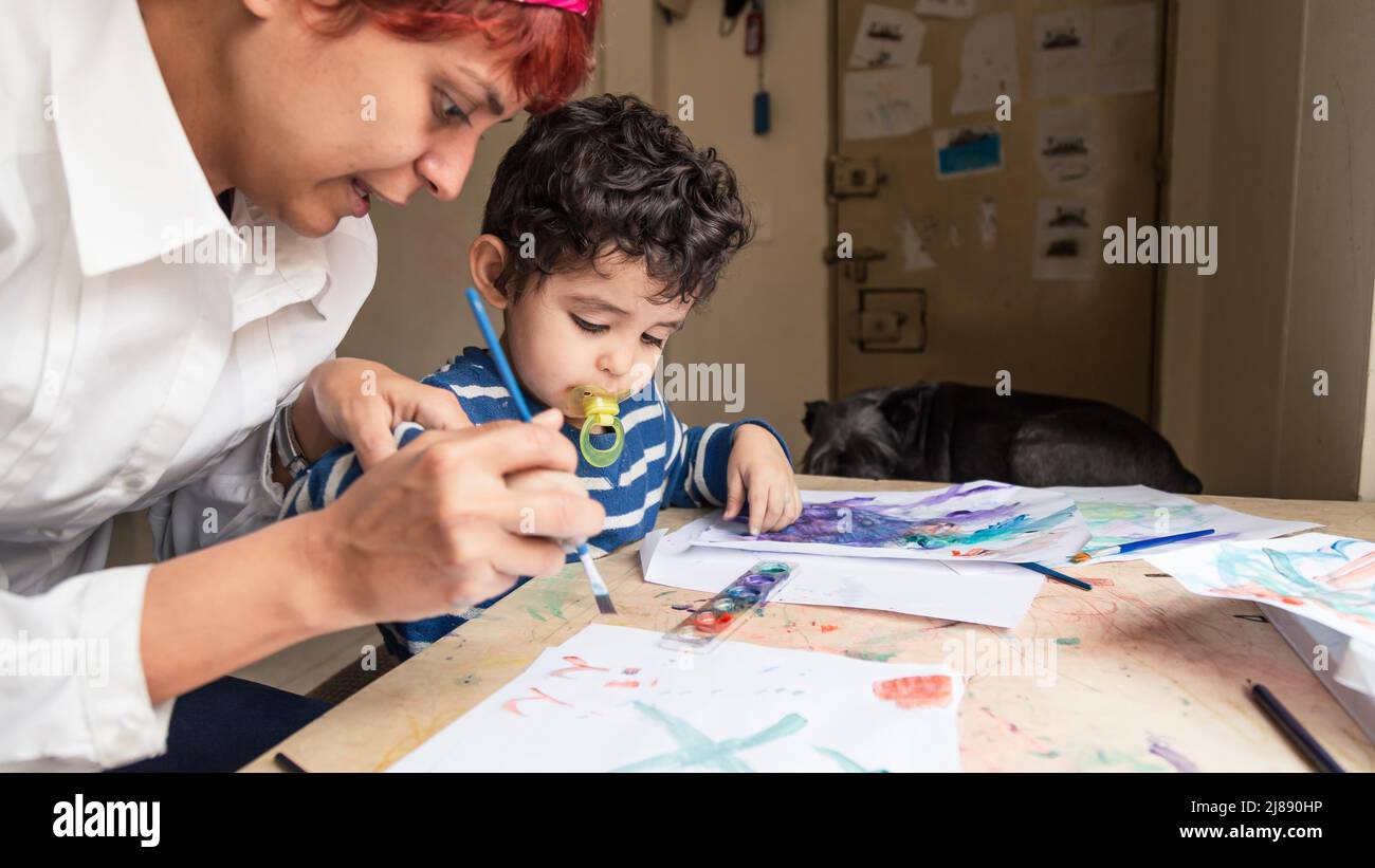 teacher teaching a child to paint with paints Stock Photo Alamy