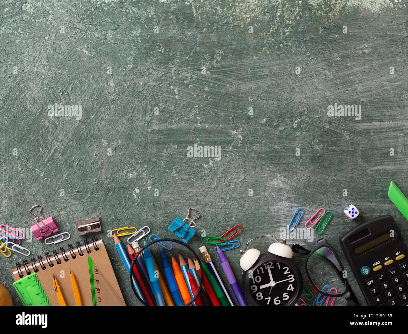 School background with school supplies and copy space. Top view, pens and pencils, notebooks, green chalk board Stock Photo