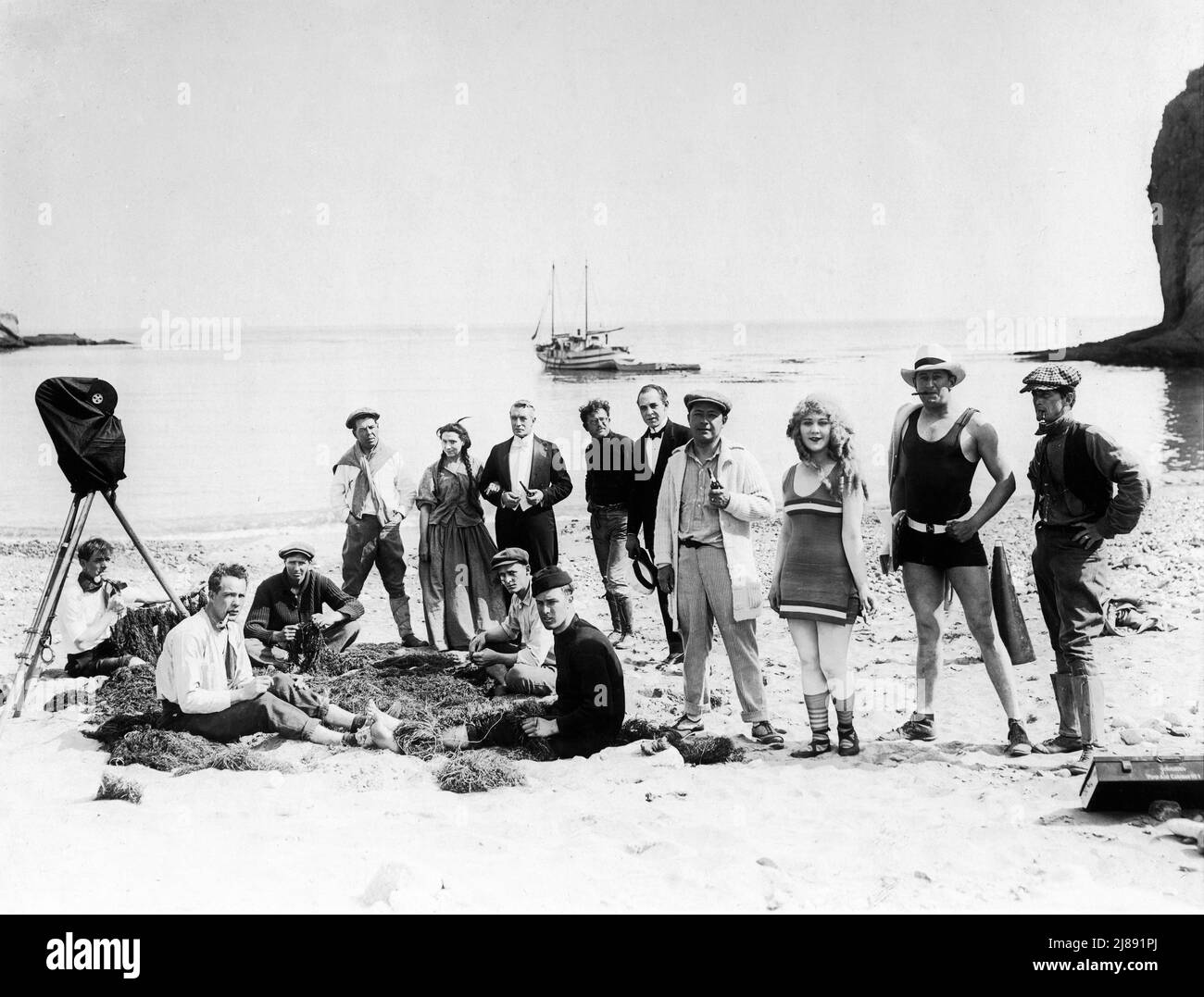 LOUISE LOVELY and Director ALLEN HOLUBAR (in black bathing outfit) with Movie Crew and Cast including likely Cinematographer ROY H. KLAFFKI (with cap and pipe) and actors HELEN WRIGHT and SYDNEY DEANE on set location candid on Catalina Island California during filming of SIRENS OF THE SEA  aka DARLINGS OF THE GODS (in UK) 1917 director / scenario ALLEN HOLUBAR story Grace Helen Bailey cinematographer Roy H. Klaffki Jewel Productions / Universal Film Manufacturing Company Stock Photo
