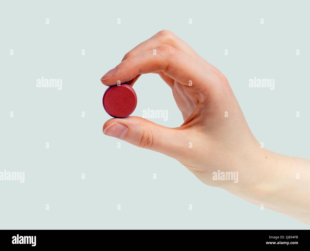 Hand with red pill or vitamin. Taking medicine, health problems, medical therapy concept. High quality photo Stock Photo