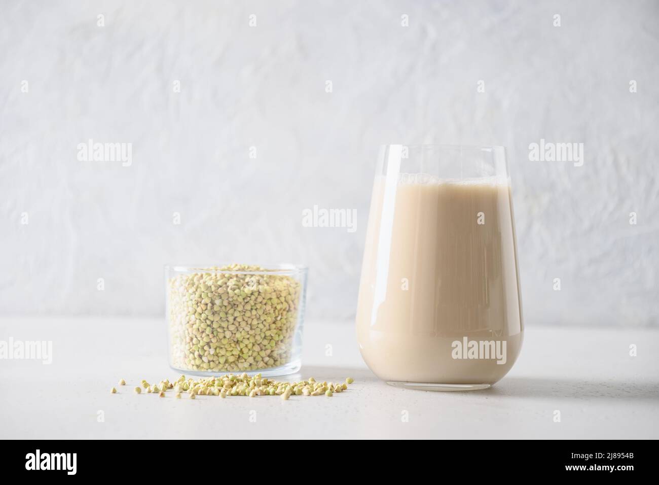 Vegan cereal green buckwheat milk in glass and on gray background. Close up. Plant based milk replacer and lactose free. Copy space. Stock Photo