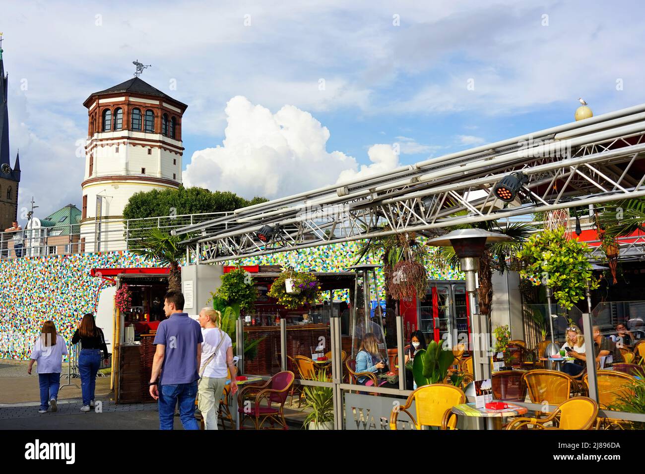 The popular tourist attraction Rhine river promenade in Düsseldorf/Germany with outdoor restaurant and historic castle tower in the background. Stock Photo