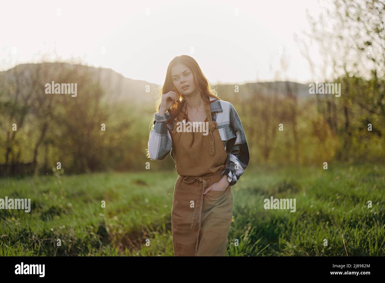 Portrait of a young smiling woman in work clothes checkered shirt and
