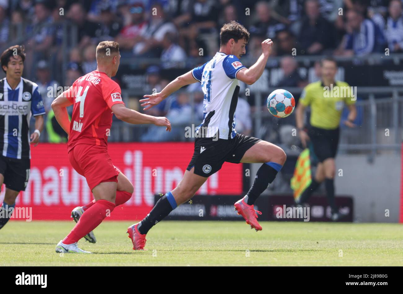 Bielefeld, Germany. 14th May, 2022. Soccer: Bundesliga, Arminia Bielefeld - RB Leipzig, Matchday 34 at the Schüco Arena. Bielefeld's Janni Serra (r) battles for the ball with Leipzig's Willi Orban (2nd from left). Credit: Friso Gentsch/dpa - IMPORTANT NOTE: In accordance with the requirements of the DFL Deutsche Fußball Liga and the DFB Deutscher Fußball-Bund, it is prohibited to use or have used photographs taken in the stadium and/or of the match in the form of sequence pictures and/or video-like photo series./dpa/Alamy Live News Stock Photo