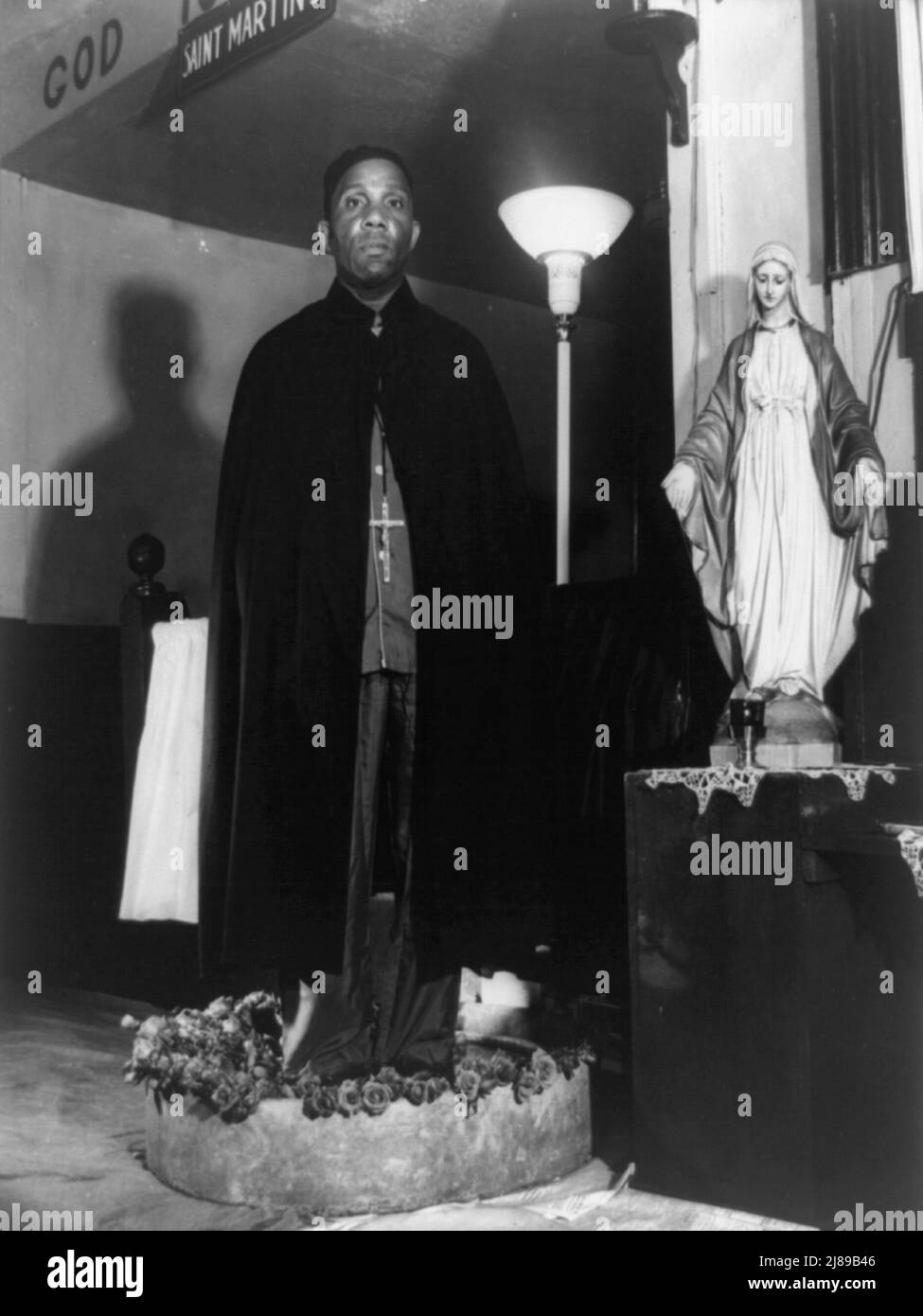 Washington, D.C. Reverend Vondell Gassaway, pastor of the St. Martin's Spiritual Church standing in a bowl of sacred water banked with roses, each of which he blesses and gives to a member who has been annointed and prayed for by a long line of disciples during the annual &quot;flower bowl demonstration&quot;. Stock Photo