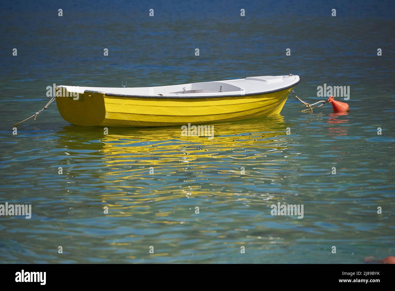 Vibrant Yellow boat in sea without people Stock Photo