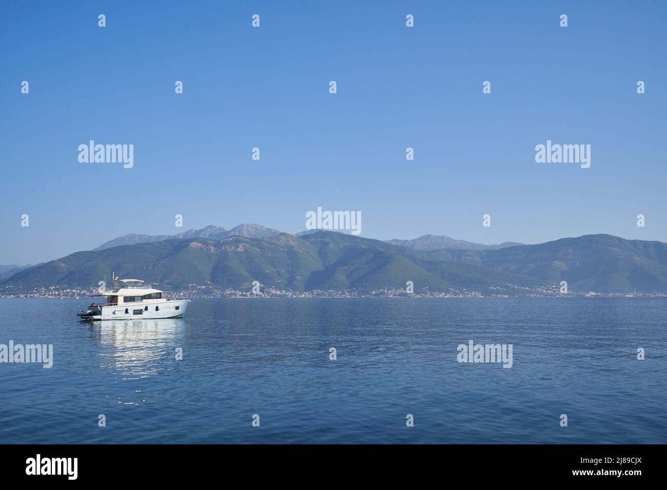 Seascape with silver yacht against the backdrop of mountains in Montenegro Stock Photo