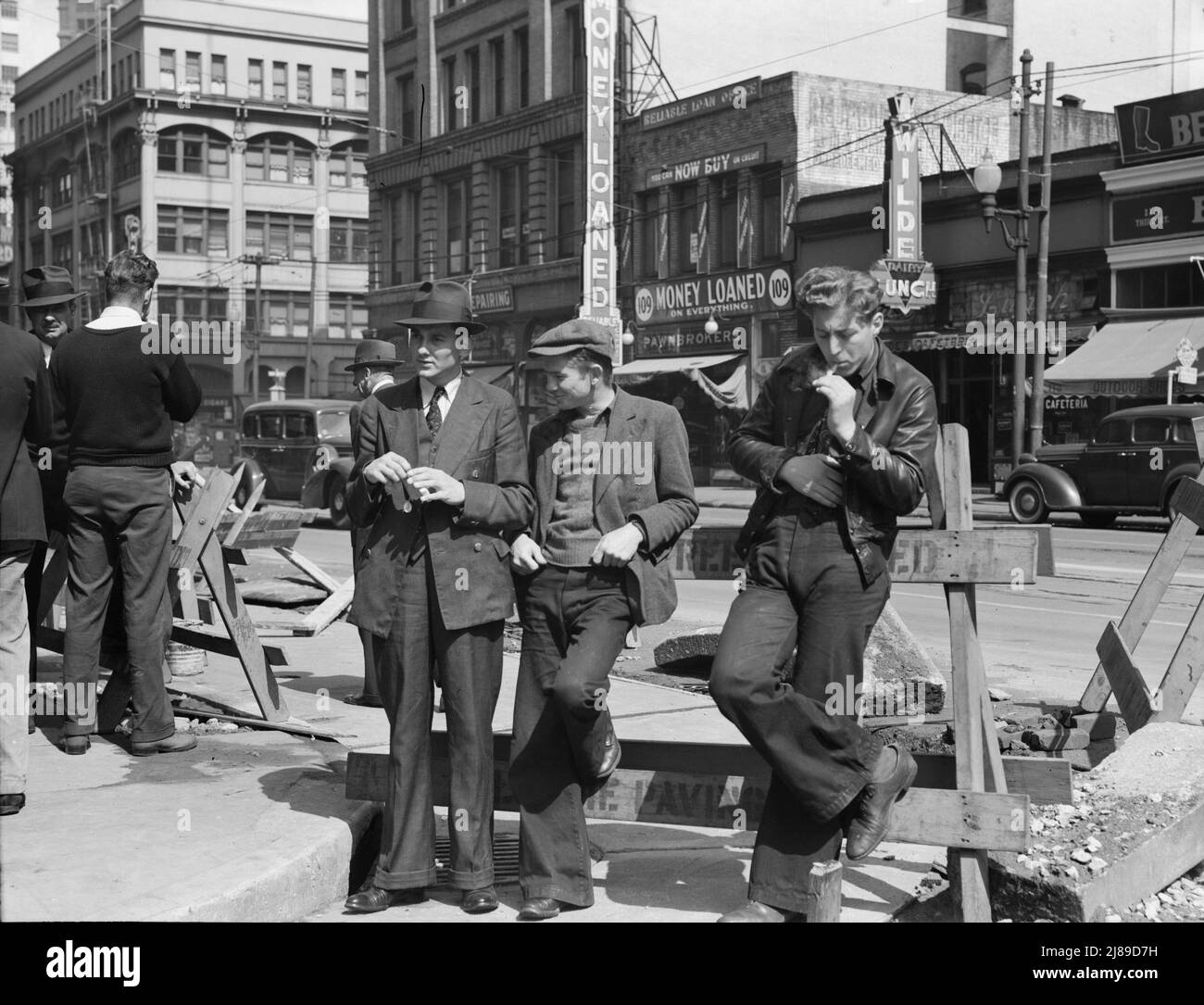 Salvation Army, San Francisco, California. Unemployed young men pause a moment to loiter and watch, and then pass on. [Signs: 'Money Loaned on Everything; Pawnbrokers']. Stock Photo