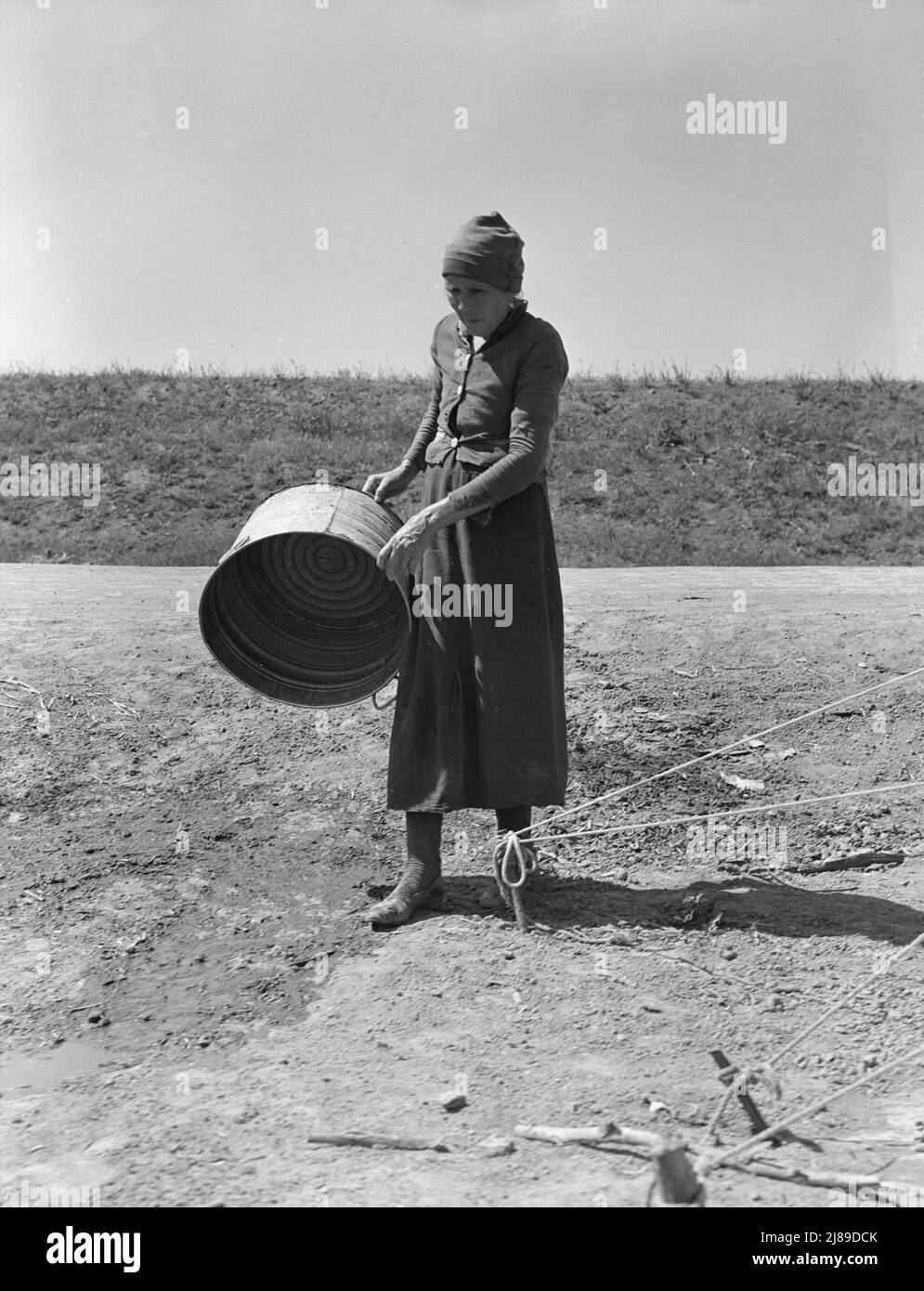 A grandmother in a migrant camp. Stanislaus County, California. &quot;Been in California fourteen months. From Oklahoma. The main thing is to get our families located and quieted down. Ain't no use to send them back; it's a waste of money. They won't stay.&quot;. Stock Photo