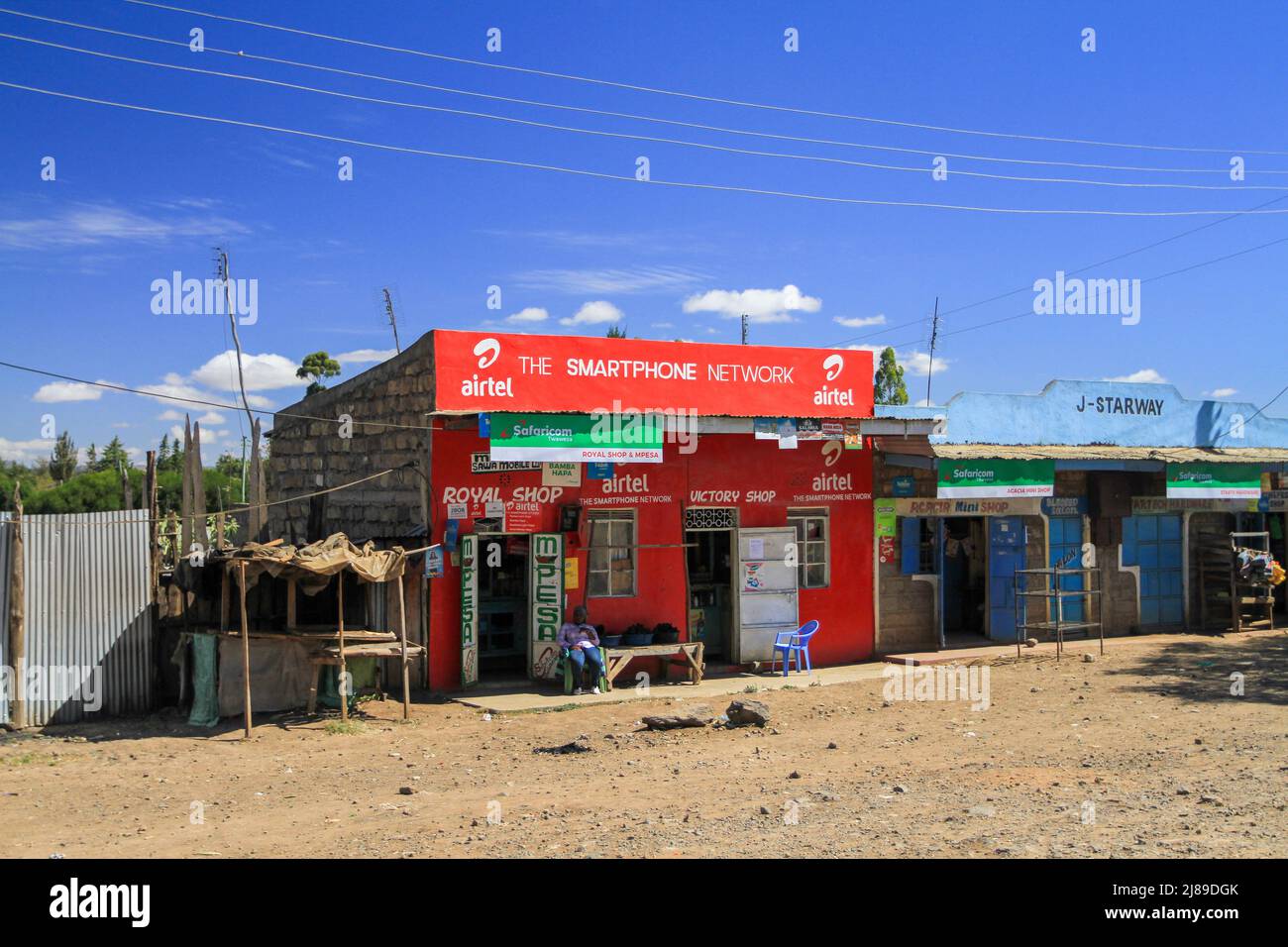 Airtel and Safaricom shops provide mobile internet networks and MPesa money transfer. Unrecognizable unrecognisable person. Village street in Kenya Stock Photo