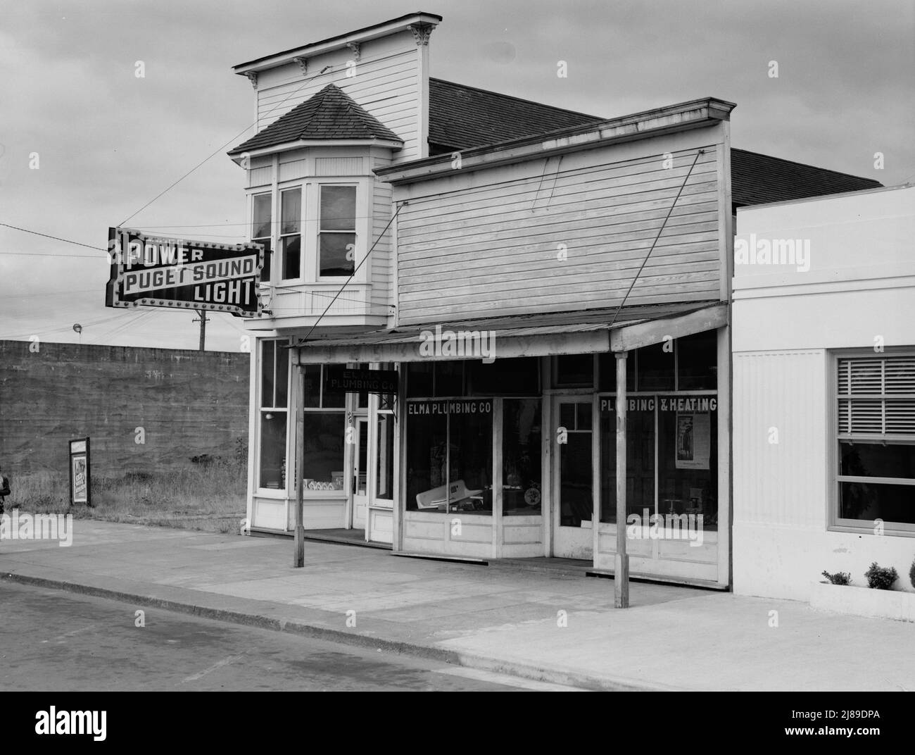 Western Washington, Grays Harbor country. Elma. Main street. Note modern building which adjoins Elma city hall. The real estate and flower business is across the street. Stock Photo