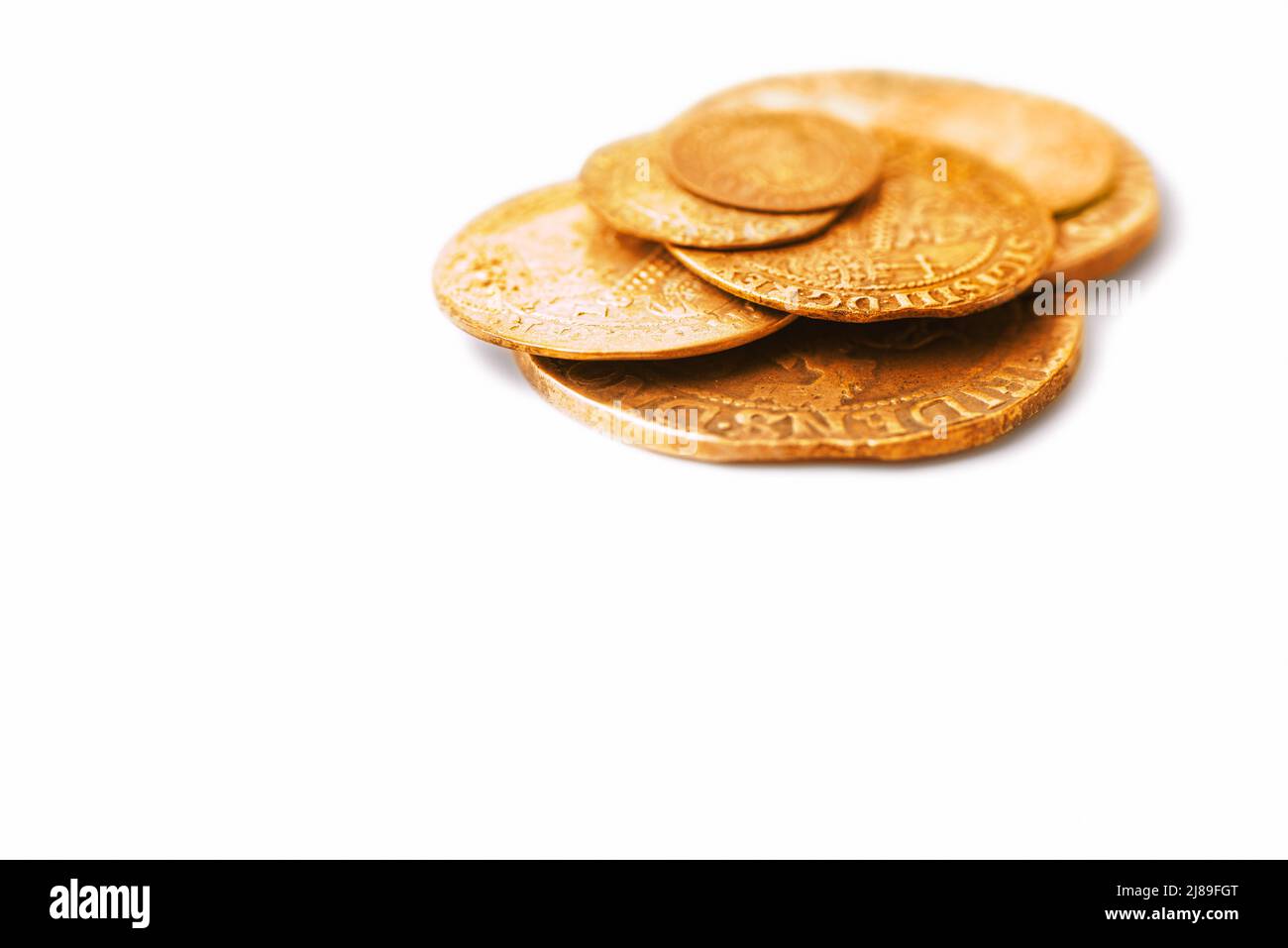Pile of old golden coins isolated on white background. Concept of savings, economic growth and wealth. Selective focus. Copy space Stock Photo